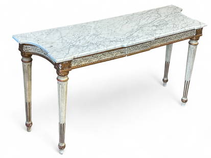 French Louis XVI Style Marble Top Console Table.: This vintage table features a carved wooden base with leaf designs and column legs. The white marble top is bevelled and cut into shape. The piece measures 31 3/4" x 59 3/4" x 19 1/2". There is a chip