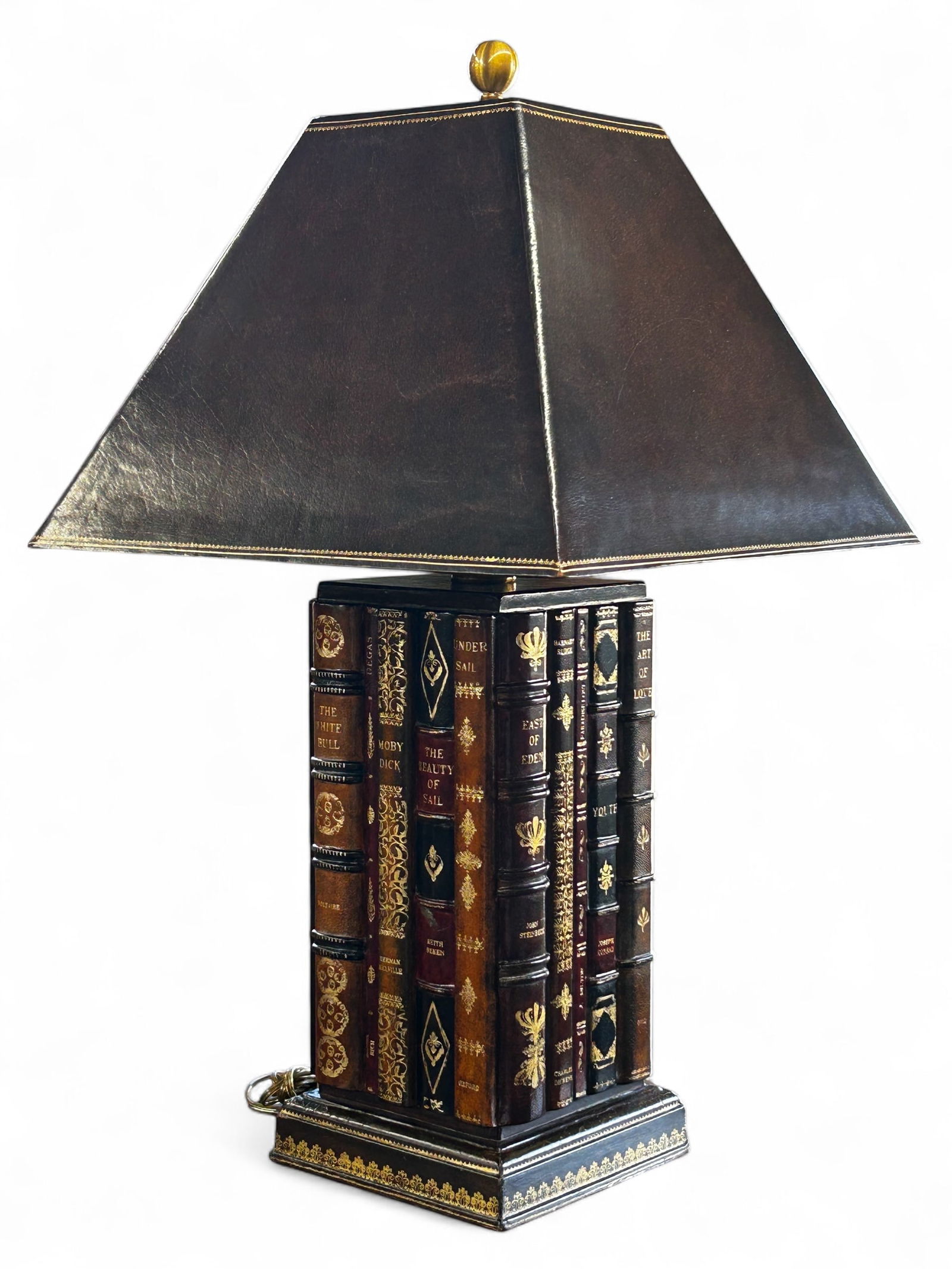 Maitland Smith Leather Wrapped Faux Book Lamp.: This lamp features a base of faux book spines on all sides, with famous titles including: Moby Dick, The White Bull, Poems, Fairy Tales, The Art of Egypt and more. The geometric shade is also leather