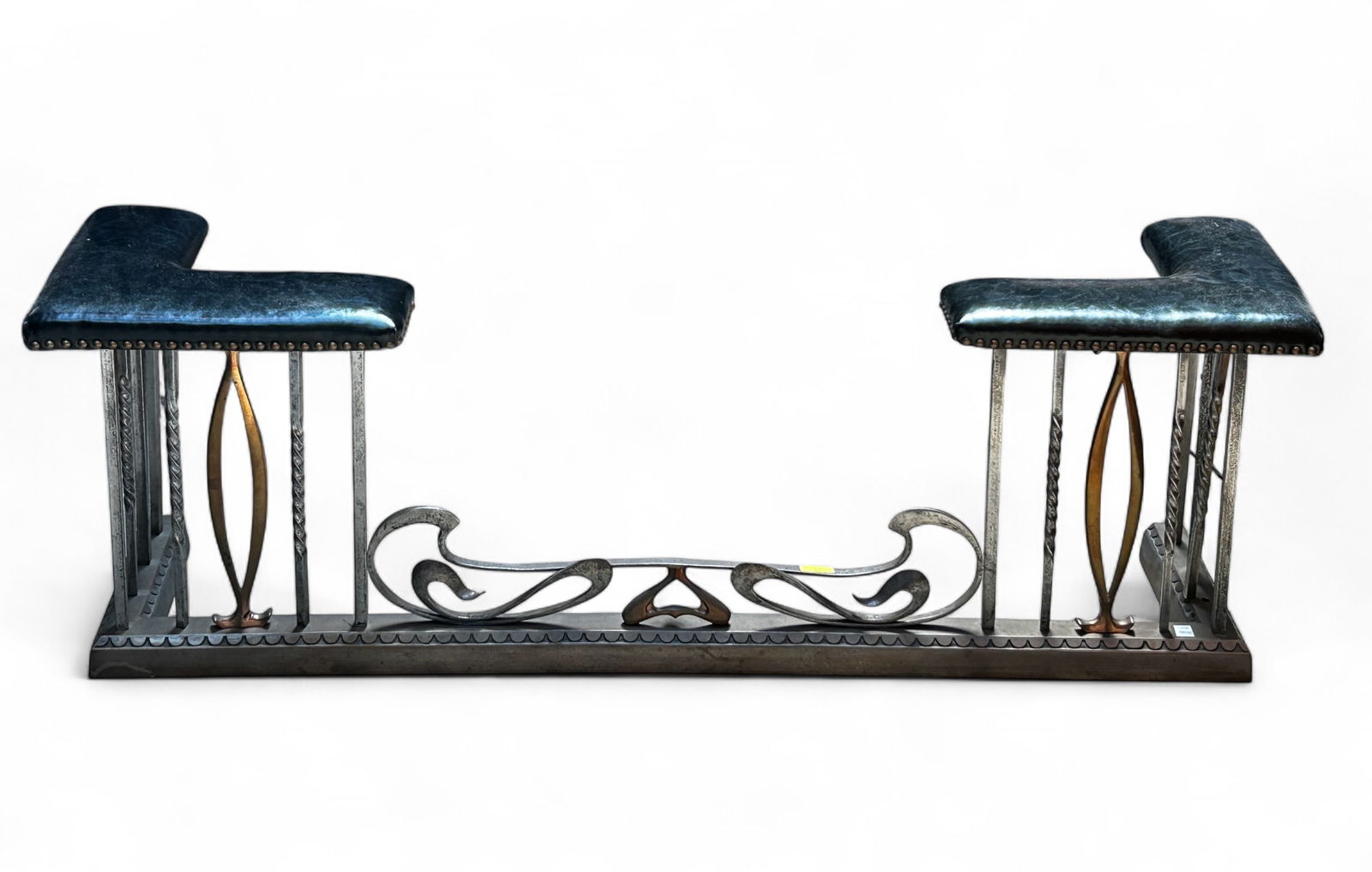 Fine Mixed Metal Fireplace Fender w/ Black Padding: The fireplace fender has a cast iron base, with iron and bronze vertical bars, and a wrought iron central decoration. The piece also has black leather ? pads with brass nail head trim. The piece measu