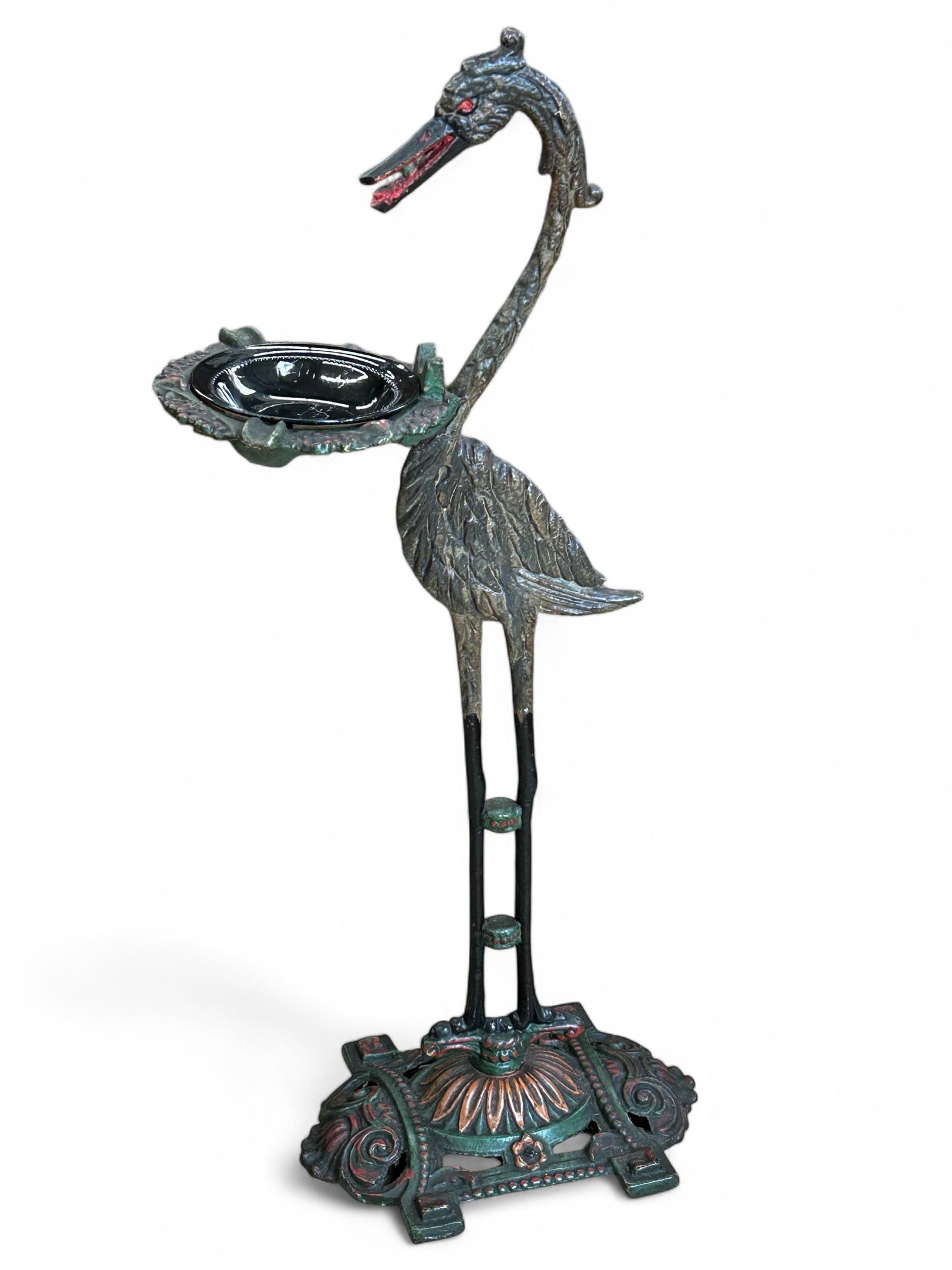 Sandel Mfg. Co. Cast Iron Ashtray Stand, Heron.: The antique ash stand features the profile of a heron or crane, and Art Deco multicolor painted designs on the base. It has a black glass ashtray, which sits on an adorned green cast iron piece with 3
