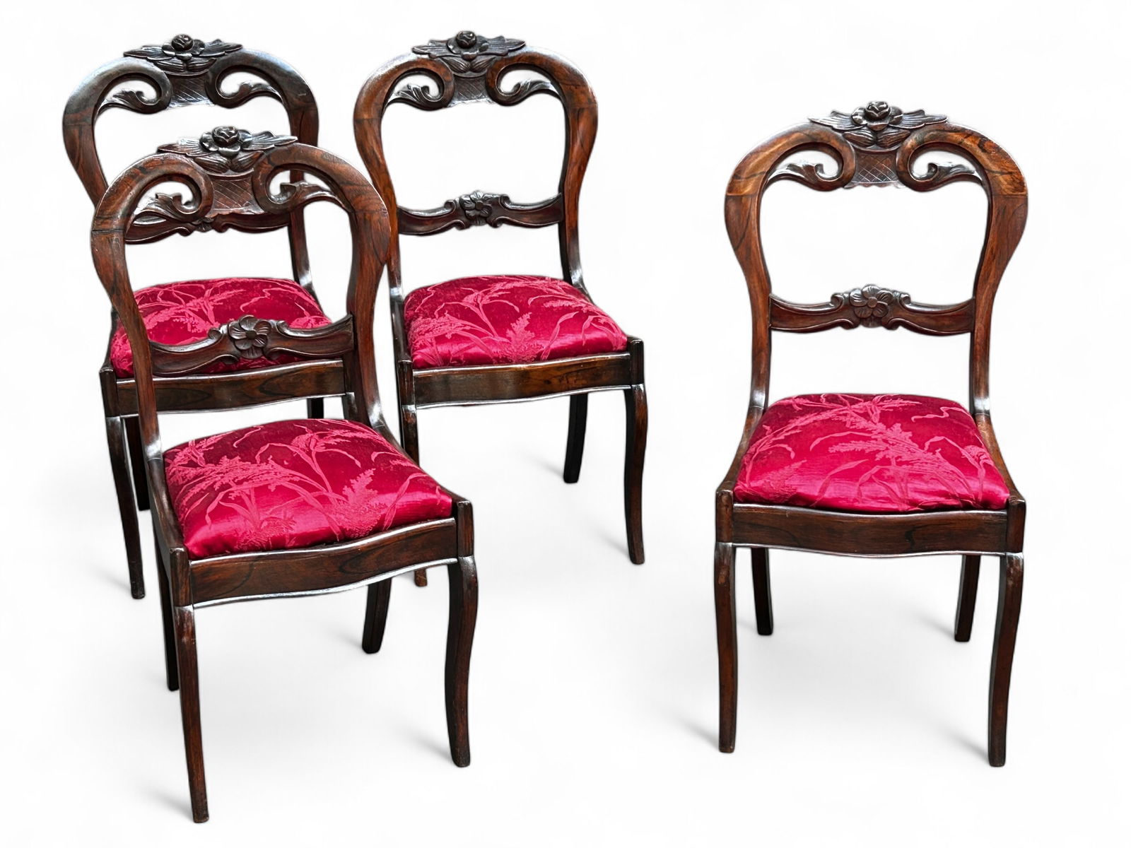 Set of Four Carved Victorian Chairs.: These four flame walnut chairs have floral carvings, pierced backs, and red floral upholstered seats. The chairs are in good overall condition, with minor scratches. Each one measures 16 1/2" wide, 15