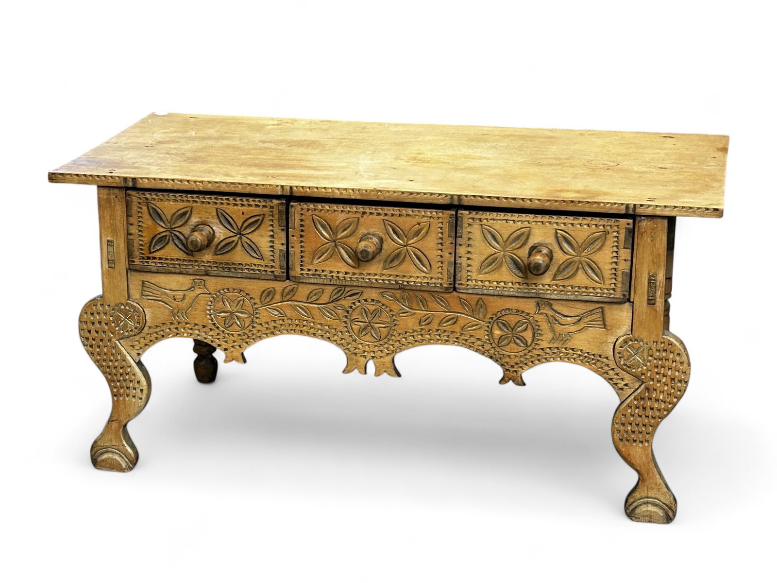 Guatemalan Carved Nahuala Console Table.: The table features three drawers with round wood pulls, a carved apron, carved front feet, turned rear legs, and a plank style overhanging top. There are scratches and discoloration on the top. Overal
