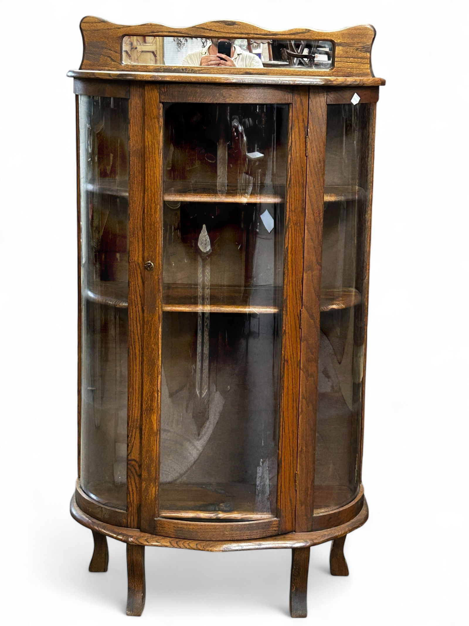 Oak Curved Glass Curio Cabinet.: This curved cabinet has a mirrored gallery top, and three shelves. It measures 33" wide, 14 1/2" deep, and 64" tall. Third-party freight shipping or personal pickup is required. Please see our website