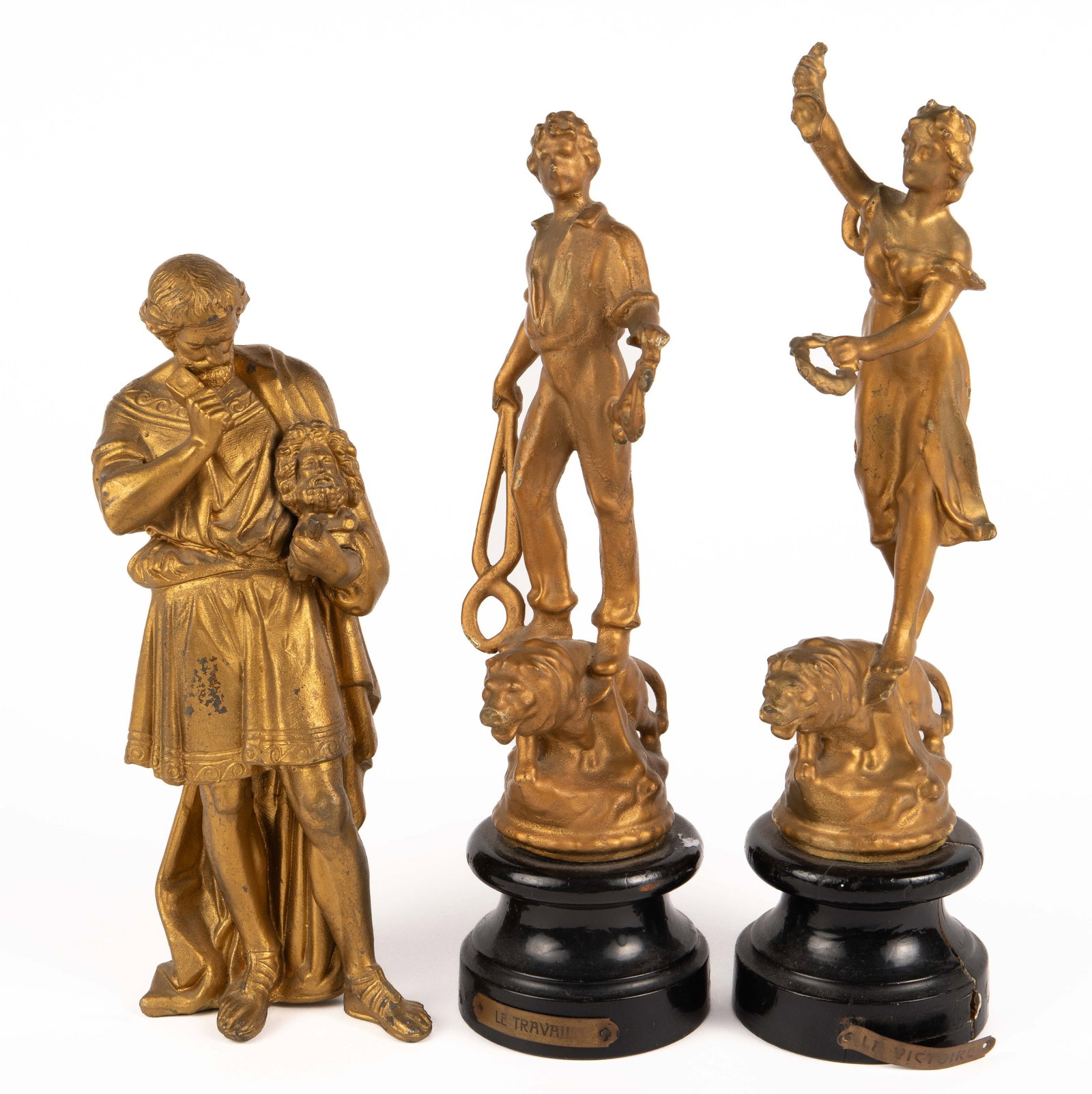 Lot of 3 Gilded Statuettes: Two are a pair; they sit on attached black wood bases. One is "Victory", the other is "Labor". The third is a spelter figure of a Greek or Roman sculptor, holding a male bust in the crook of his elbow