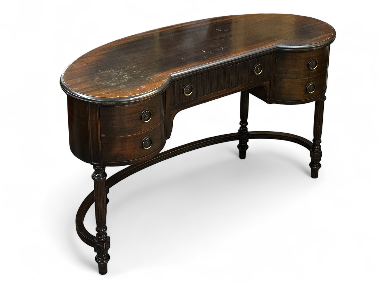 Vintage Imperial Company Kidney Desk.: This mahogany desk has five drawers with brass pulls. is signed on the inside of the middle drawer, which has a linenfold carving on the outside. The fluted legs are connected via a stretcher, and dec