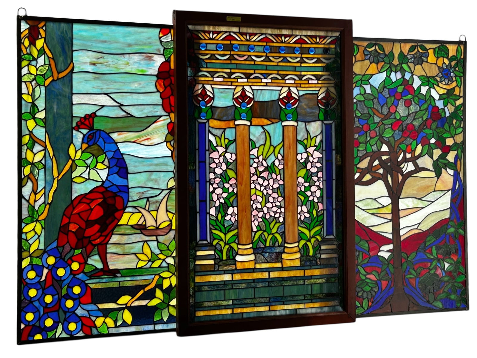 Lot of 3 Contemporary Stained Glass Windows.: The lot contains 3 stained glass windows. One of them features an apple tree, one features a peacock, and the other, which is in a wooden frame, depicts columns and flowers. Two of the windows are als