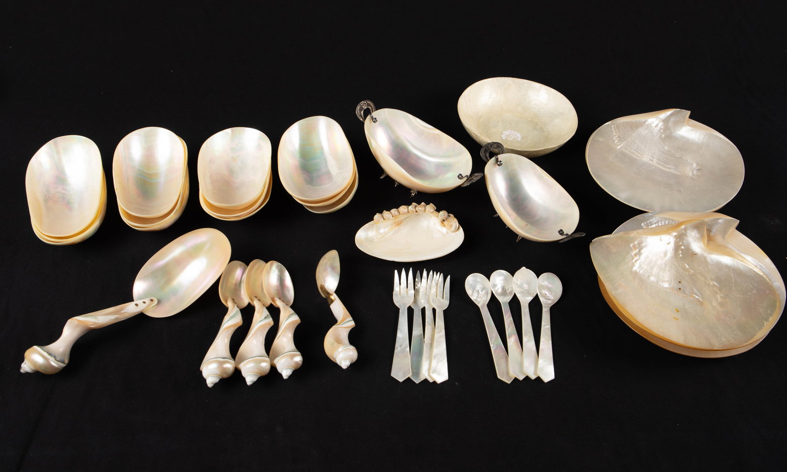 Lot of Abalone Mother of Pearl Dishes & Utensils.: There are 34 pieces total. The lot includes shell plates, bowls, forks, and spoons. Two of the bowls have attached silver tone stands with filigree handles. Overall, the lot looks to be in good condit