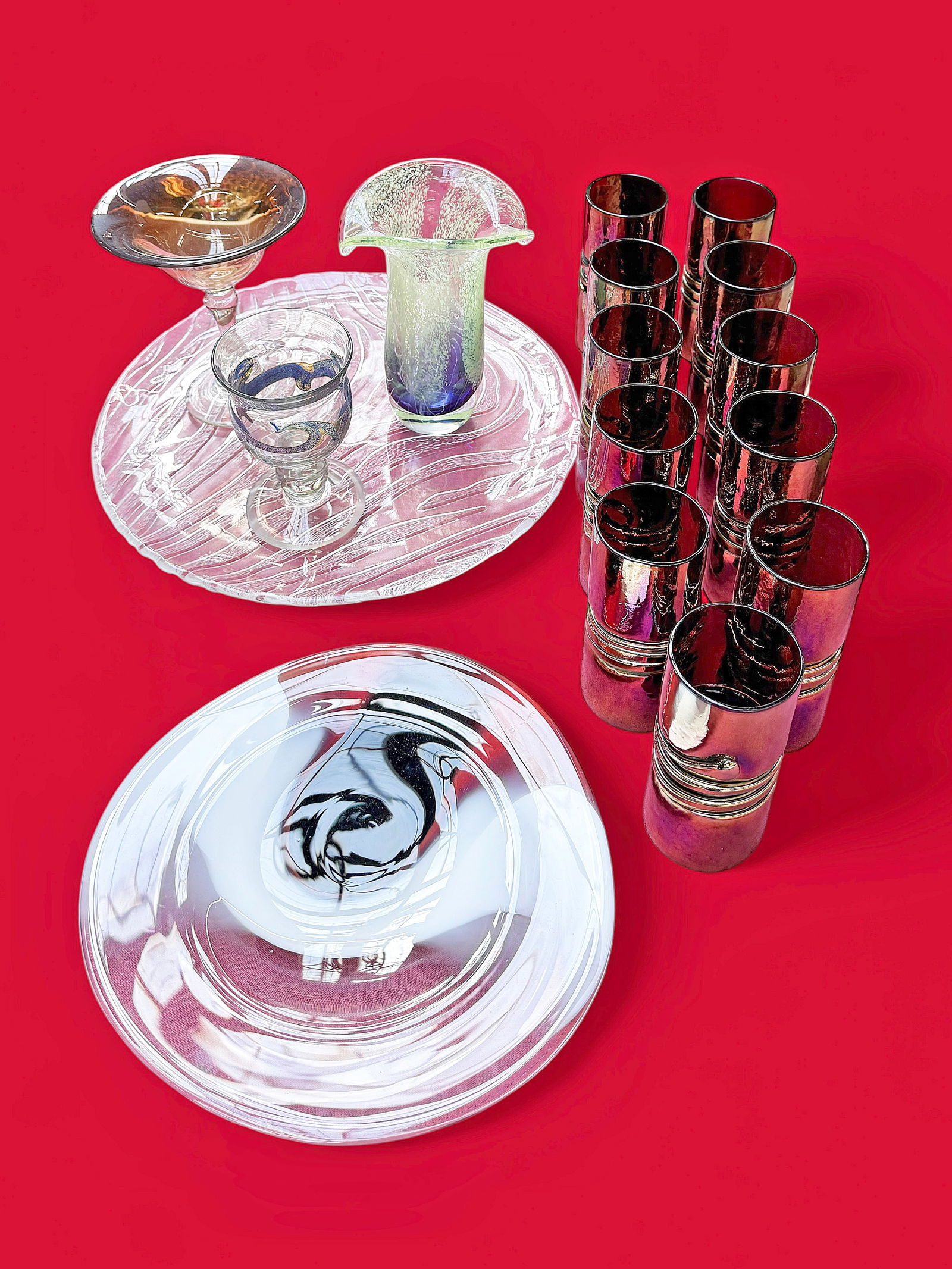 Lot of Art Glass, inc. Esteban Prieto.: This lot includes a Shaun Weisbach plate, a goblet signed, "Lutner", a compote signed, "Cornell", a set of 11 Esteban Prieto iridescent glass tumblers, and more. Overall, the lot looks to be in very n