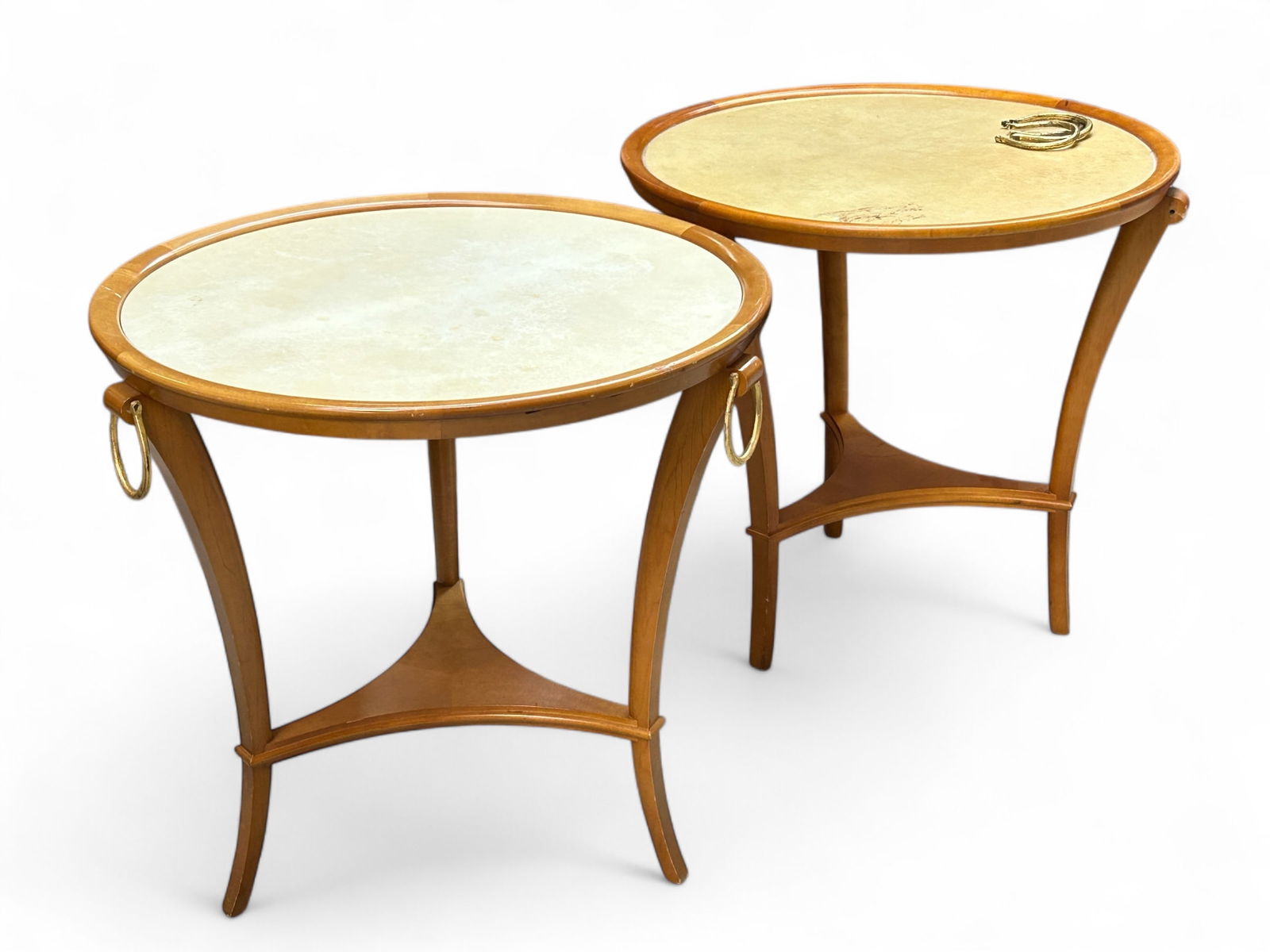 Pair of Andre Arbus Style End Tables.: The tables appear to be unsigned, but are in the style of Andre Arbus. These end, lamp, or gueridon tables have circular leather inset tops, and are supported by three curved legs connected by a stret