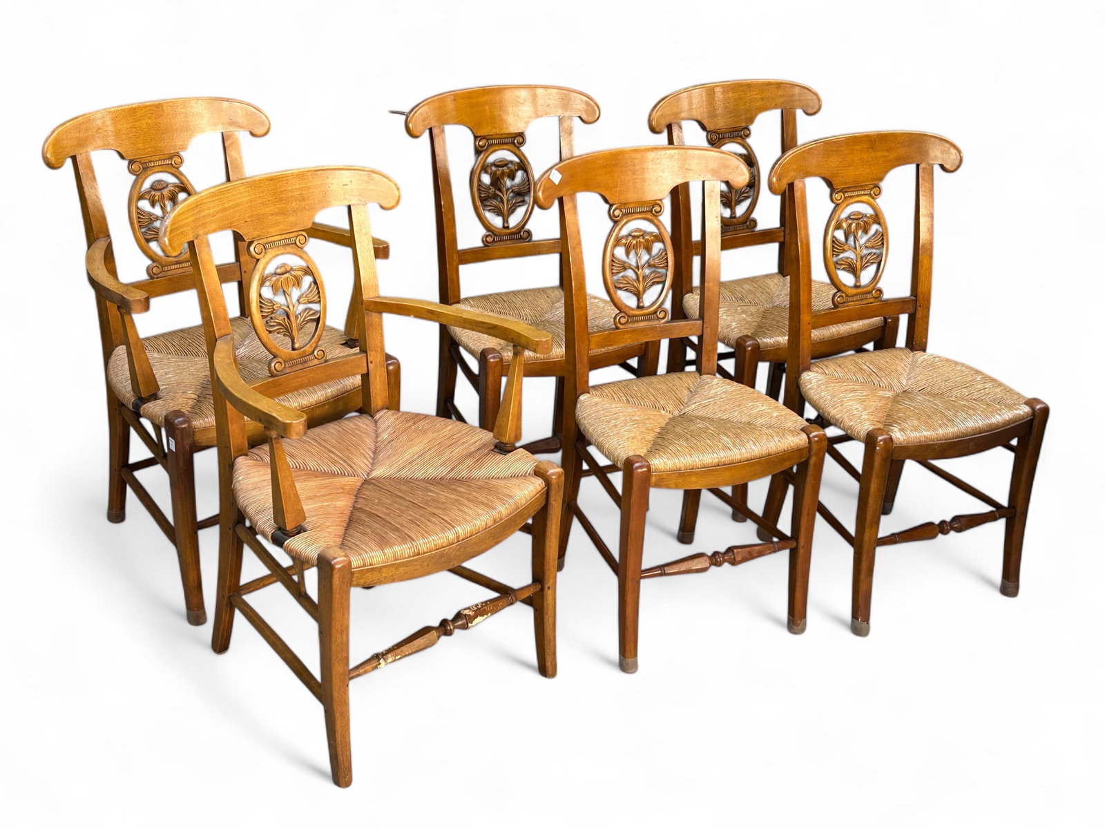 Lot of Six Carved Dining Chairs.: These elegant light wood chairs feature rush seats and carved floral splats. Two of the chairs have arms. Overall, they are in good condition, with some wear. The chairs with arms measure 24 1/2" wide