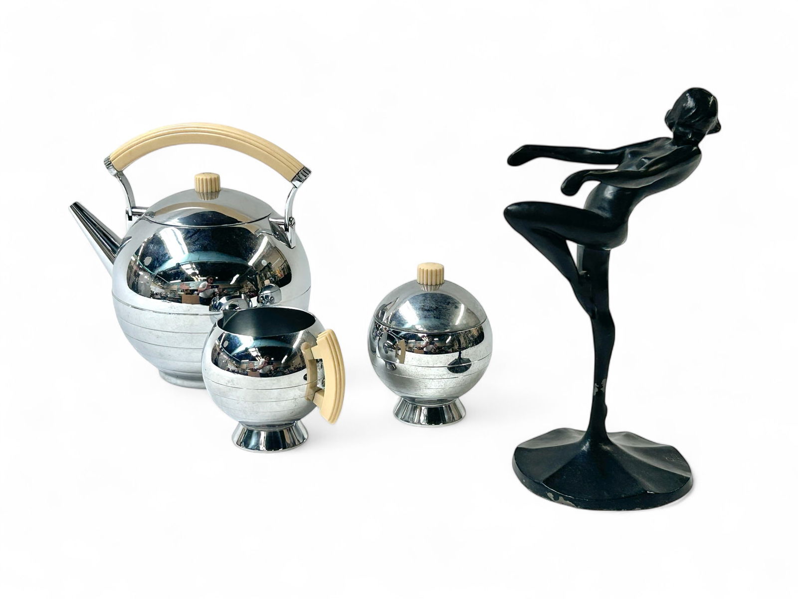 Art Deco Items - Chase Tea Set & Frankart Figure.: The lot contains 4 items. First, there is a Frankart metal figural sculpture of a dancing nude woman. It is signed C 1922 on the base. Next, there is a 3 piece chrome and bakelite tea set by Chase USA