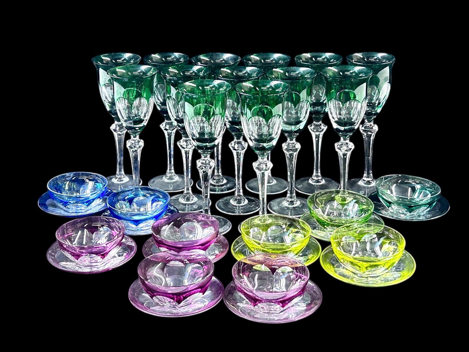 Lot: Moser Cut to Clear Goblets, Bowls w/Saucers.: This lot contains a set of 13 green cut to clear crystal wine goblets, in overall nice condition. Each goblet measures 9 1/4" tall and 3 1/4" across the rim. The lot also includes a set of 10 cut to c