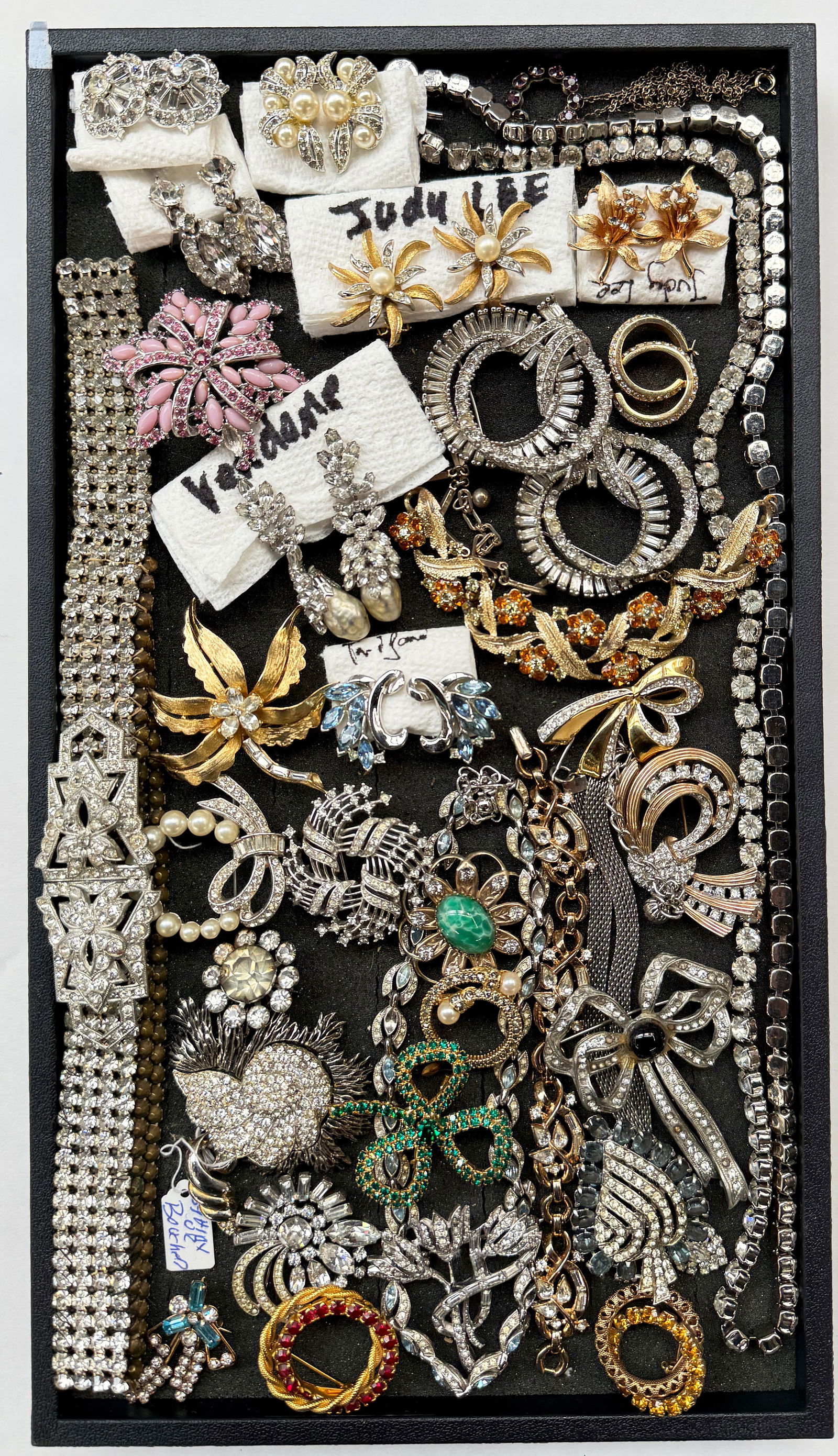 Lot of Designer Rhinestone Jewelry - Pell, Ledo.: The lot contains 36 pieces of vintage jewelry. There are earrings, necklaces, brooches, a bracelet, and a belt. Some pieces are gold filled. The brands or marks observed are Trifari, KC, Judy Lee, Sta