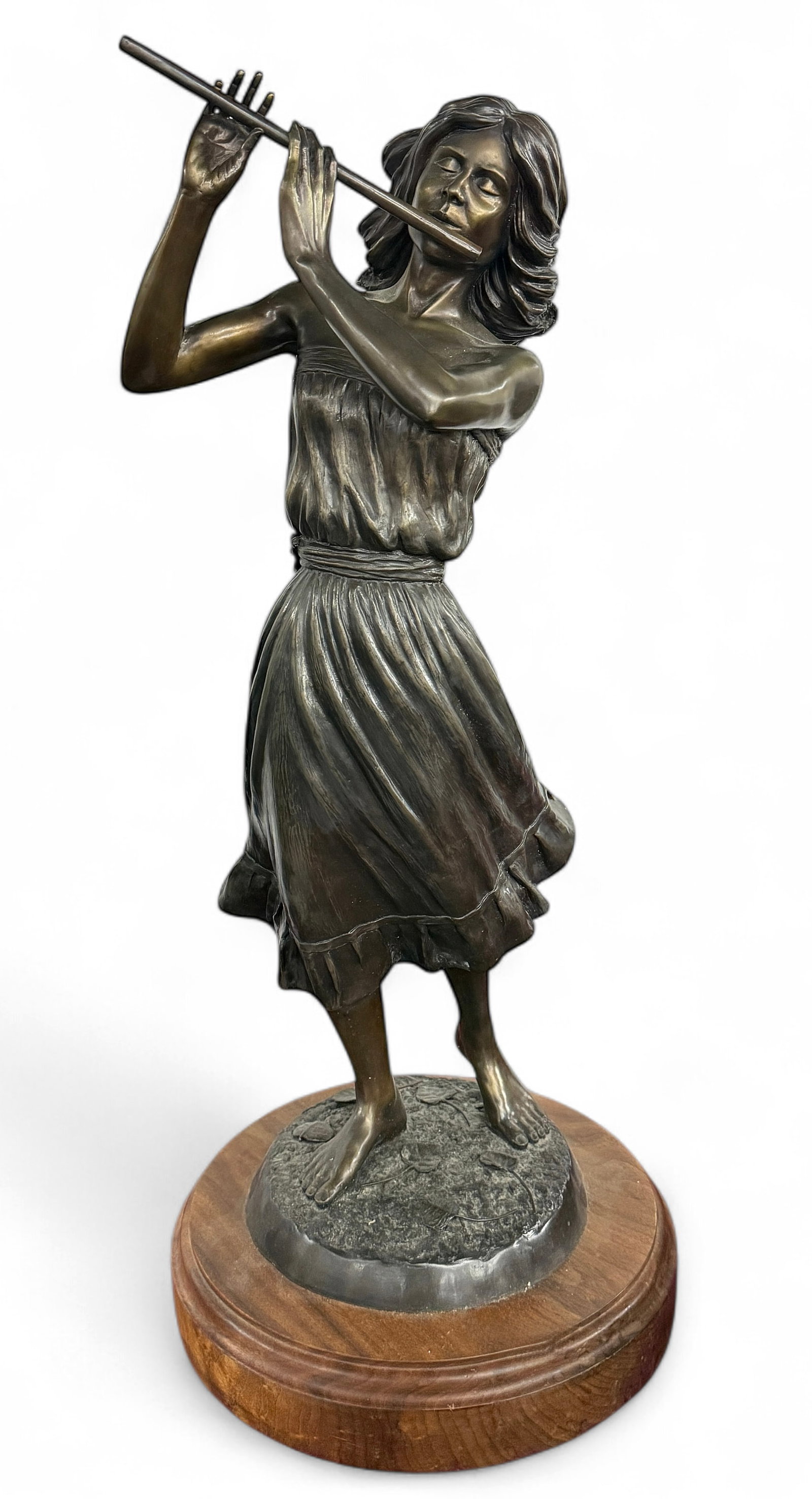 28" Bronze of Woman Playing Flute.: It is on an attached swiveling wood stand. The sculpture is signed by artist Reagan Word, numbered 8/25, and produced by Buffalo Bronze Works. Overall, the sculpture looks to be in very good condition