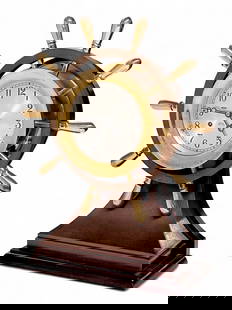 Chelsea Ship's Bell "Mariner" Wheel Mantel Clock.: The keywind clock features a ship wheel decoration. It is mixed metal, with a wooden base and back mount. It measures 17 1/2" x 14" x 5 1/2". It is untested. There are some stains and scratches on