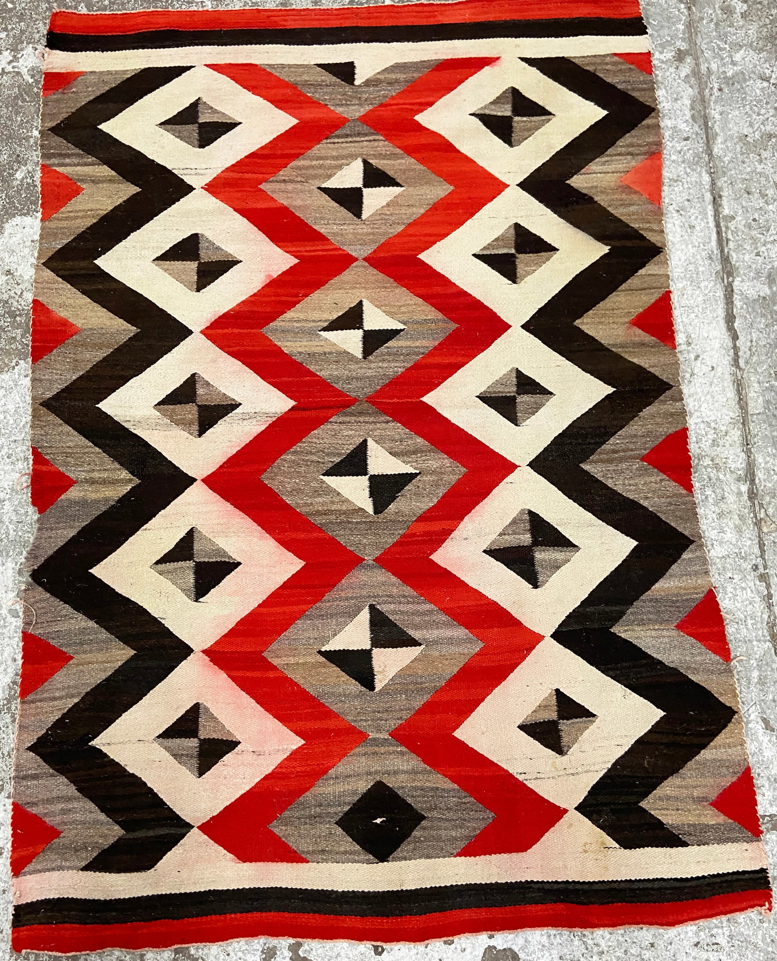 5' 1" x 7' 4" Turn of the Century Navajo Rug.: The rug has some minor stains and some losses on the edges (see photos). Otherwise, it is in good overall condition. In-house shipping is available for this rug. Please see our website about in house 