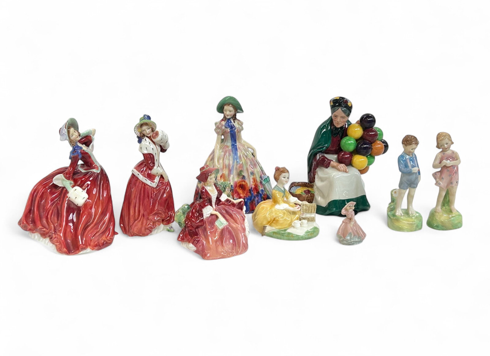 Lot of 8 Royal Doulton Figurines.: This lot includes "The Old Balloon Seller", "Easter Day", "Autumn Breezes", "Christmas Morn", "Lydia", "Picnic", "He Loves Me", and "She Loves Me Not". They look to be in very nice condition. Also inc