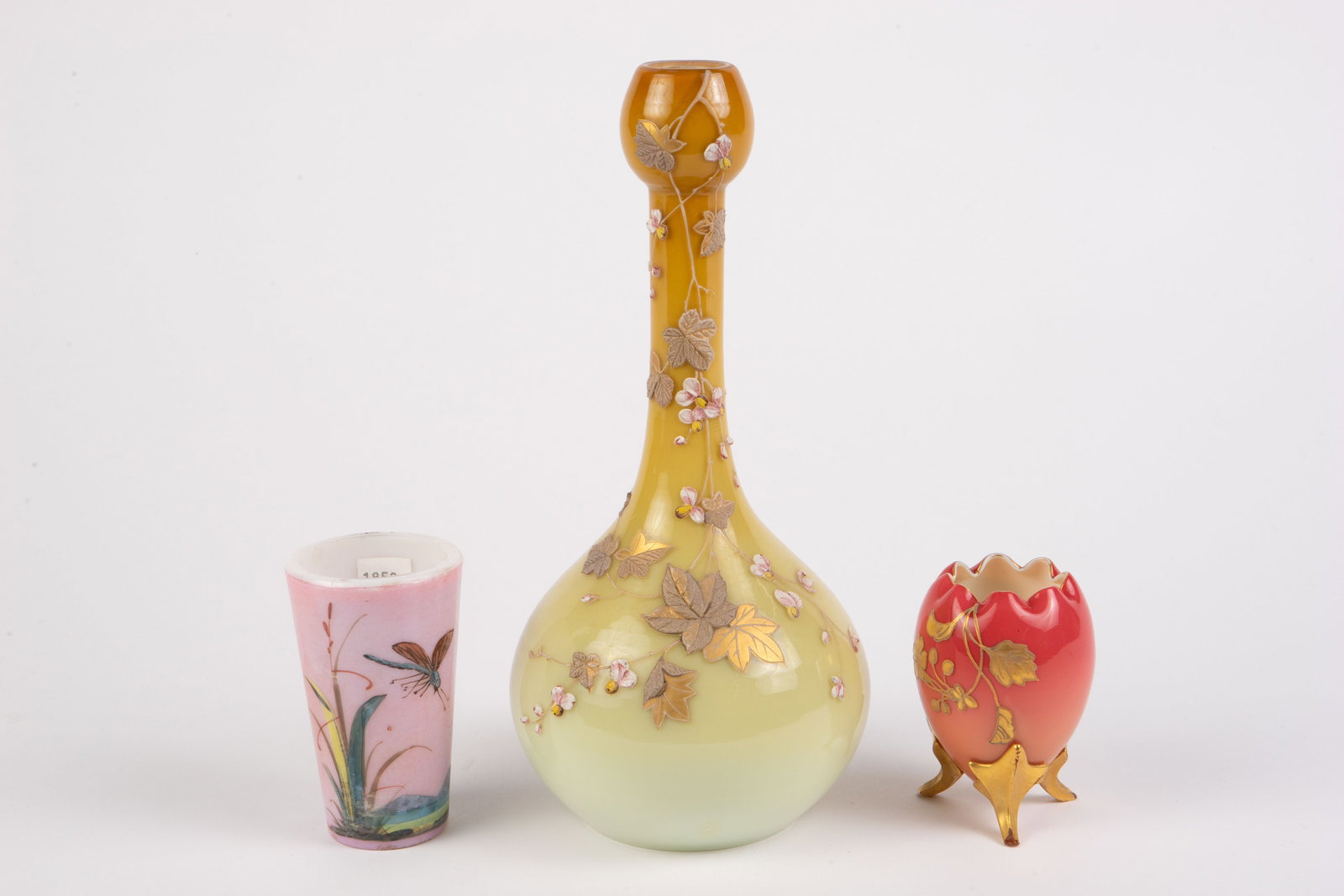 Lot: 3 Hand Painted Glass Pcs., inc. Thomas Webb.: The lot includes a golden yellow autumnal vase with painted flowers and leaves, most likely by Thomas Webb. The lot also includes a small footed egg-shaped vase or toothpick holder, and a dragonfly-th