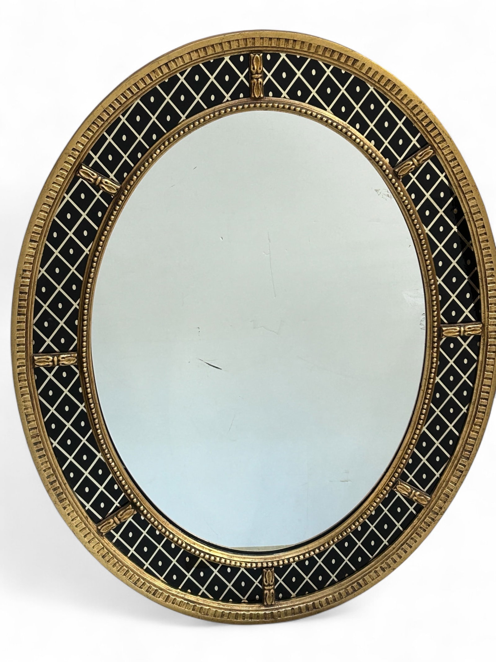 Mario Buatta for Widdicomb Eglomise Mirror.: This oval mirror has black and silver gilding, along with a beaded design. It is in good condition. The mirror measures 42" tall and 32" wide. Third-party freight shipping or personal pickup is requir