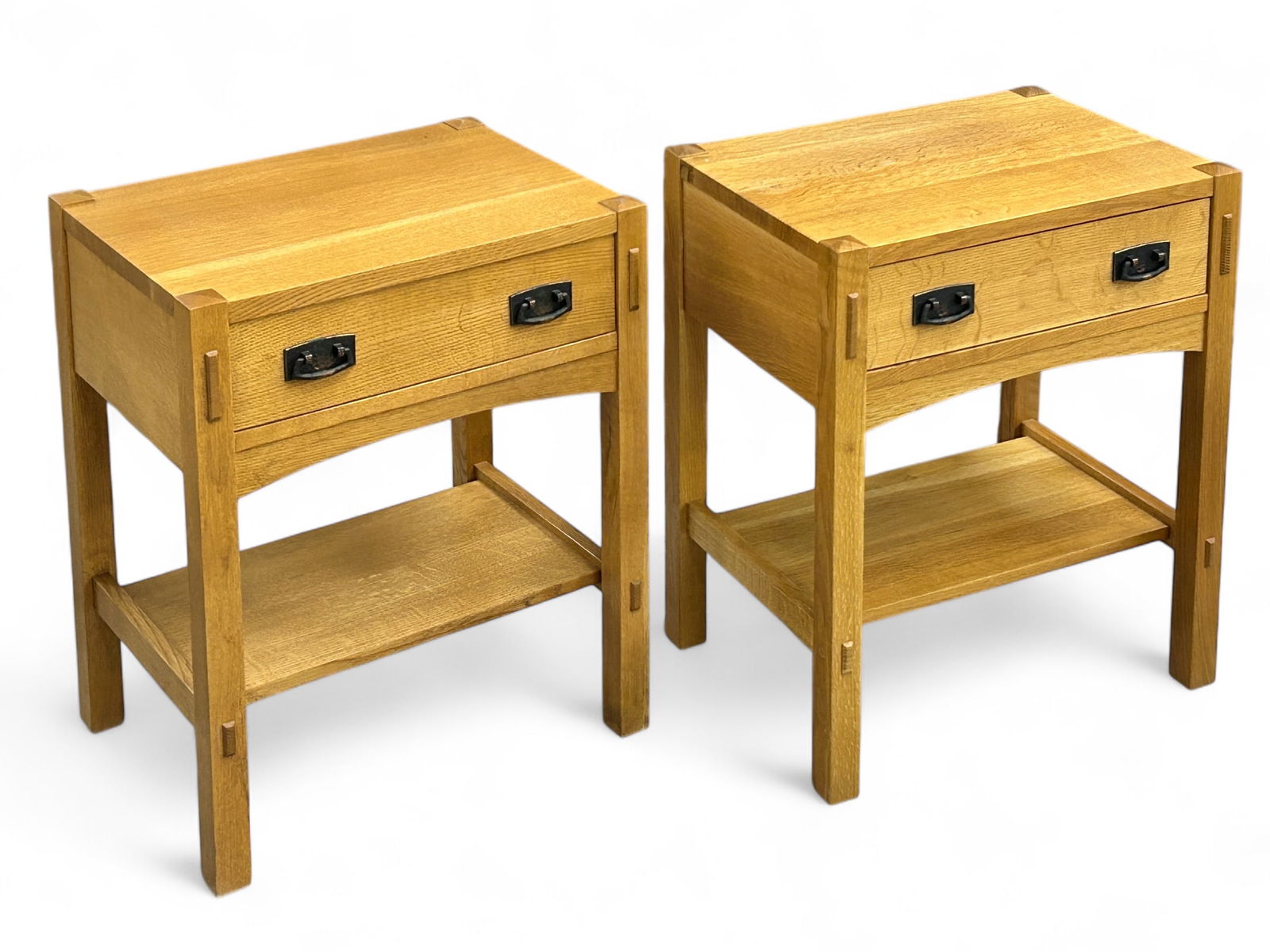 Pair of Stickley Mission Oak Nightstands.: These signed honey oak nightstands each have one drawer and a lower tier. The hardware is dark copper or bronze. Both pieces are in good condition, with only minor scratches. Each measures 22" wide, 1