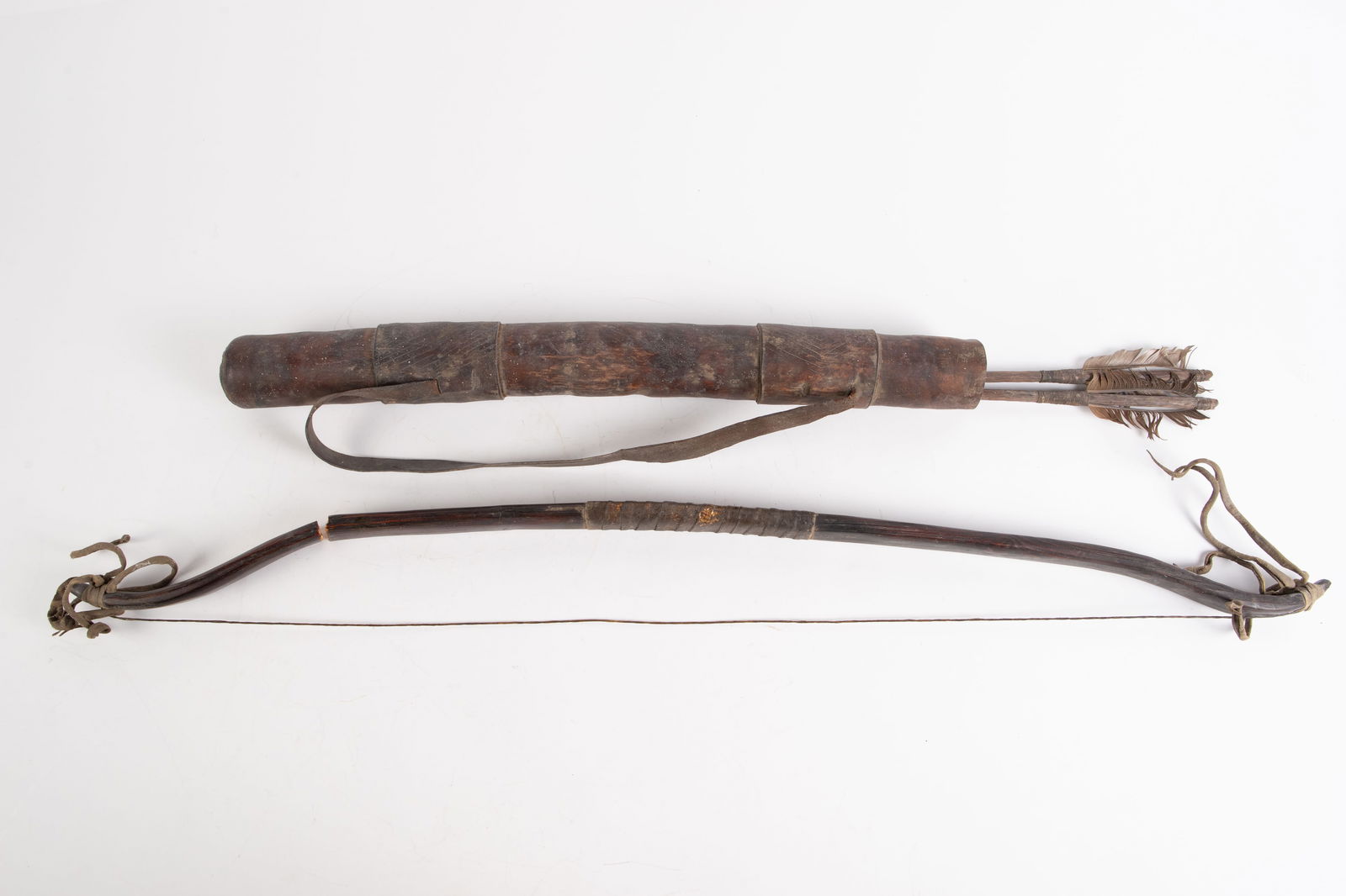 Tribal Bow, Arrows, and Quiver.: This lot includes a wood quiver, two arrows with stone arrowheads, and an as is bow (it will need to be repaired). The bow is the largest item in the lot, measuring 1 5/8" x 3/4" x 31 1/2". The arrows