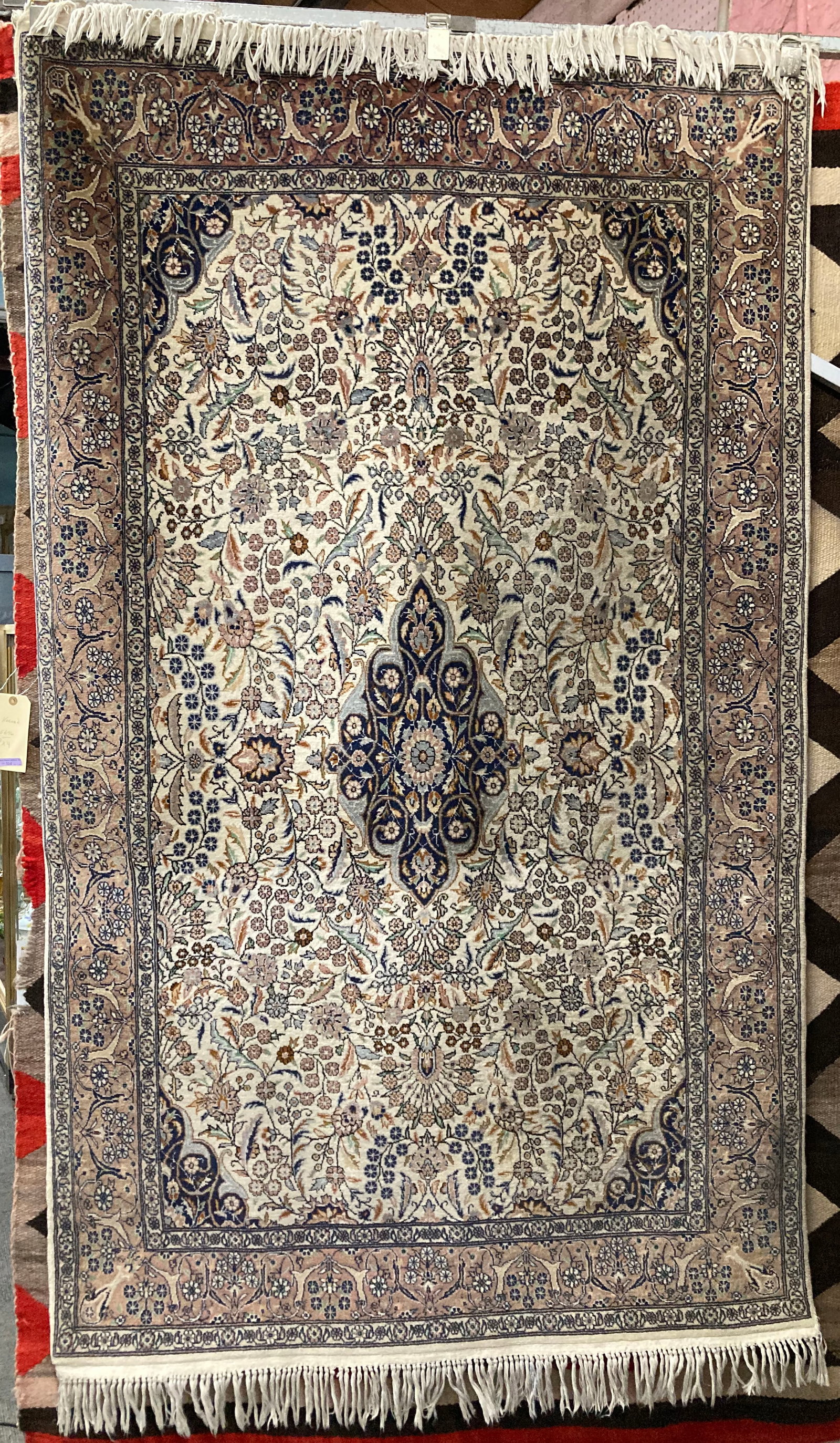 4' x ' 8" Beige & Cobalt Kashan Rug.: One side of the rug looks to be a little darker than the other side. Perhaps it could use a cleaning. Otherwise, the rug looks to be in good overall condition. In-house shipping is available for this 
