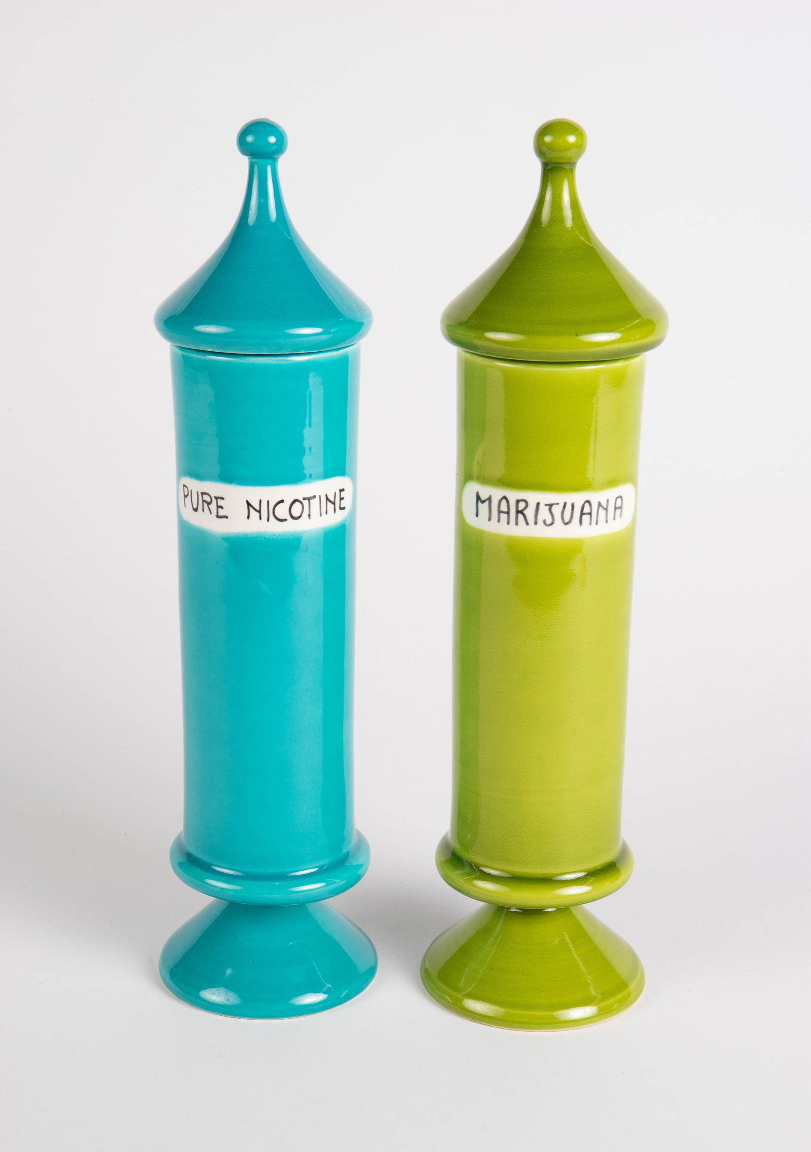 Alvino Bagni for Raymor Pair of Lidded Vice Jars.: The green apothecary style jar reads, "Marijuana" and the blue jar reads, "Pure Nicotine". Both look to be in very nice condition. Both are signed, and one still has the original Raymor tag. Bagni may