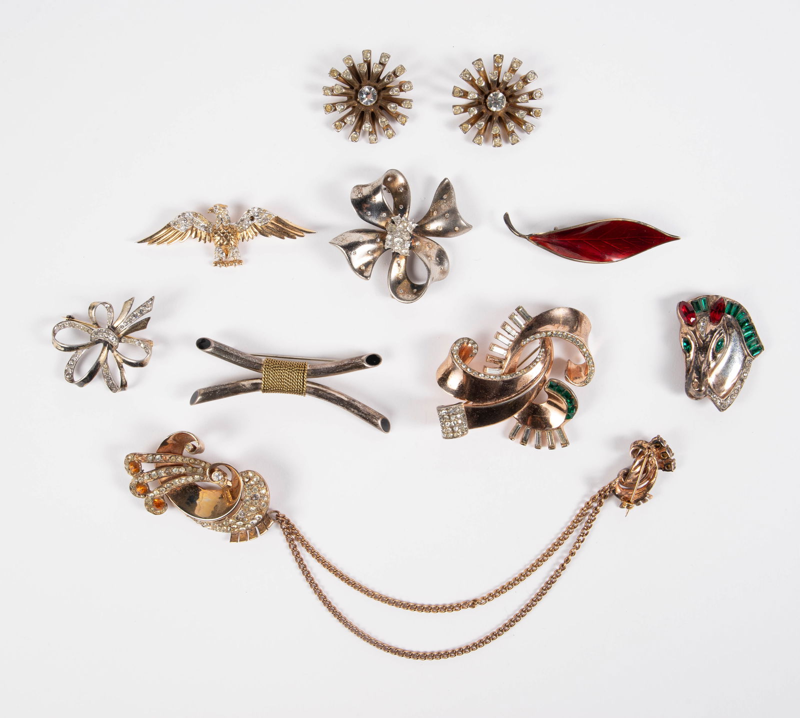 Lot of Sterling Silver Brooches - Boucher, Trifari: The lot contains 10 vintage sterling silver brooches, including a sweater guard. There is a piece by Marcel Boucher, an enameled leaf piece marked Norway, a large piece by Glamour, and an an eagle and