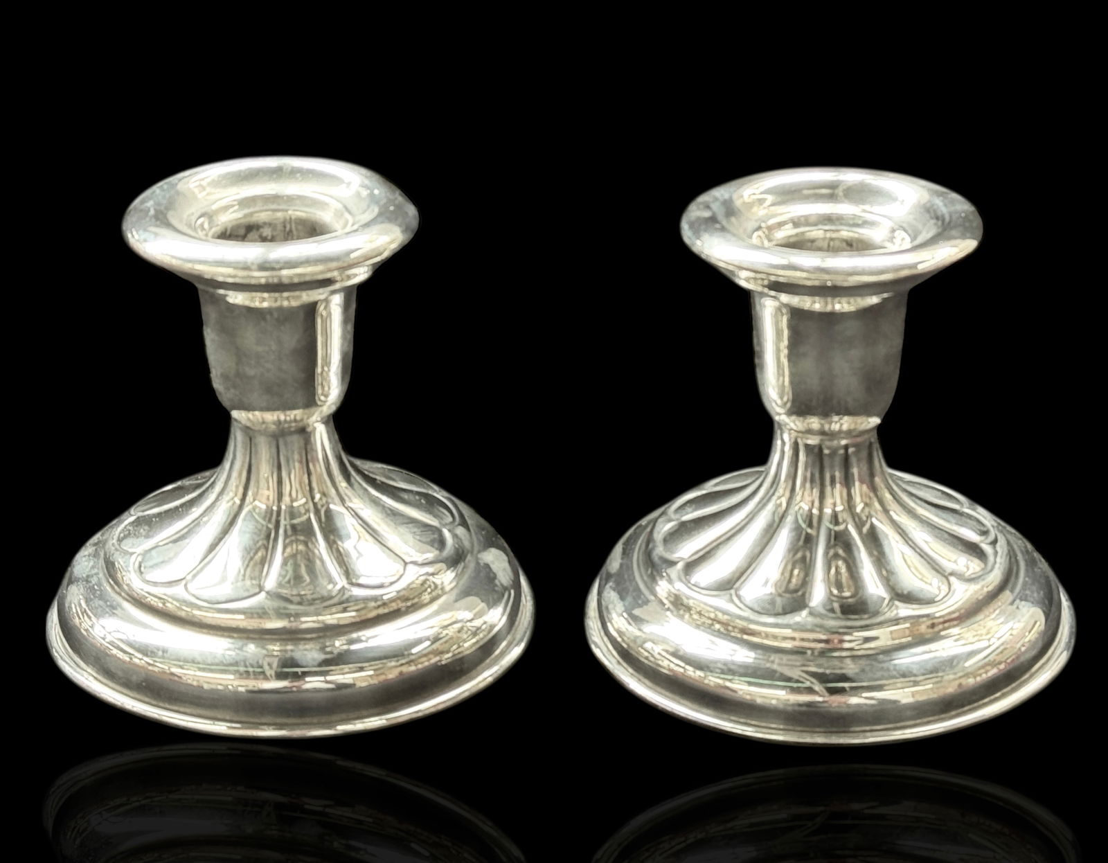 Pair of Sterling Silver Candlesticks.: The pair of candlesticks are marked Sterling / 935 on the undersides. They measure 4" x 4 1/4" x 4 1/4". The pair weighs 14.58 Oz. Troy, or 453.4 Grams (including the wax residue and any interior fill