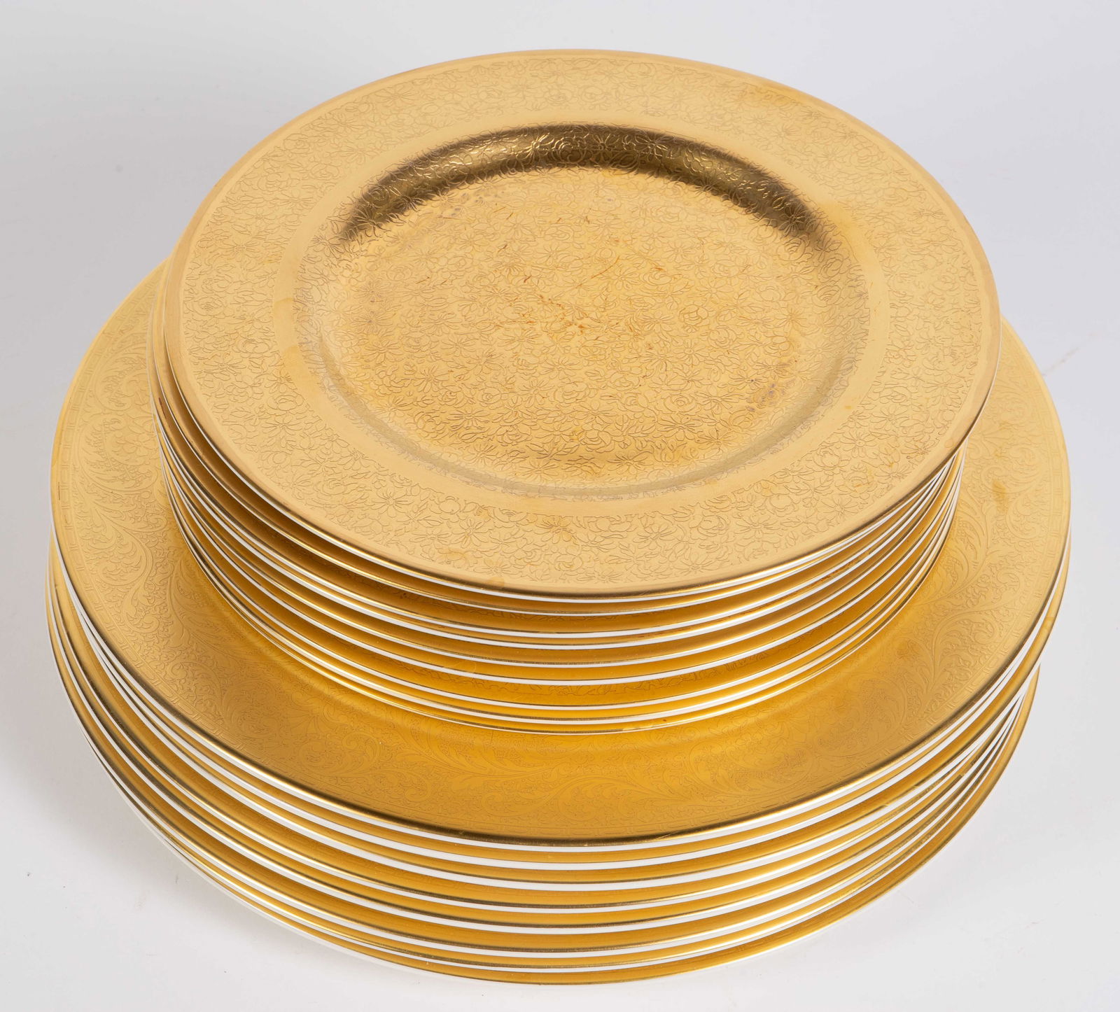 Lot of 17 Pickard China Gilded Plates, 2025 & 656: The lot consists of 17 porcelain plates by Pickard China. There are 8 dinner plates in the style #2025, with white centers and gilded paisley style decorations on the wide rim. The lot also contains 9