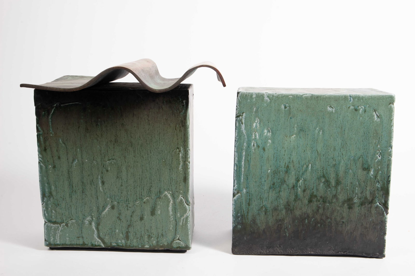 Lot of 2 Green Glaze Pottery Slab Sculptures.: The plain slab measures 9 1/2" x 4 1/2" x 10 3/4". The slab with the bronze wavy surface measures 12" x 8 1/4" x 12 1/2". The pieces are unsigned. In-house shipping is available. Please see our websit
