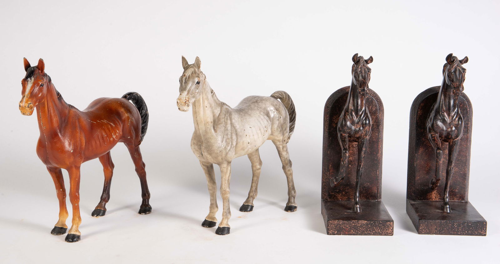 Lot of Horse Items - Bookends, Cast Iron Doorstops: This lot includes a pair of painted bookends (one has a damaged leg), a brown cast iron horse, and a gray cast iron horse. These cast iron horses have some scratches and paint loss, but are in otherwi