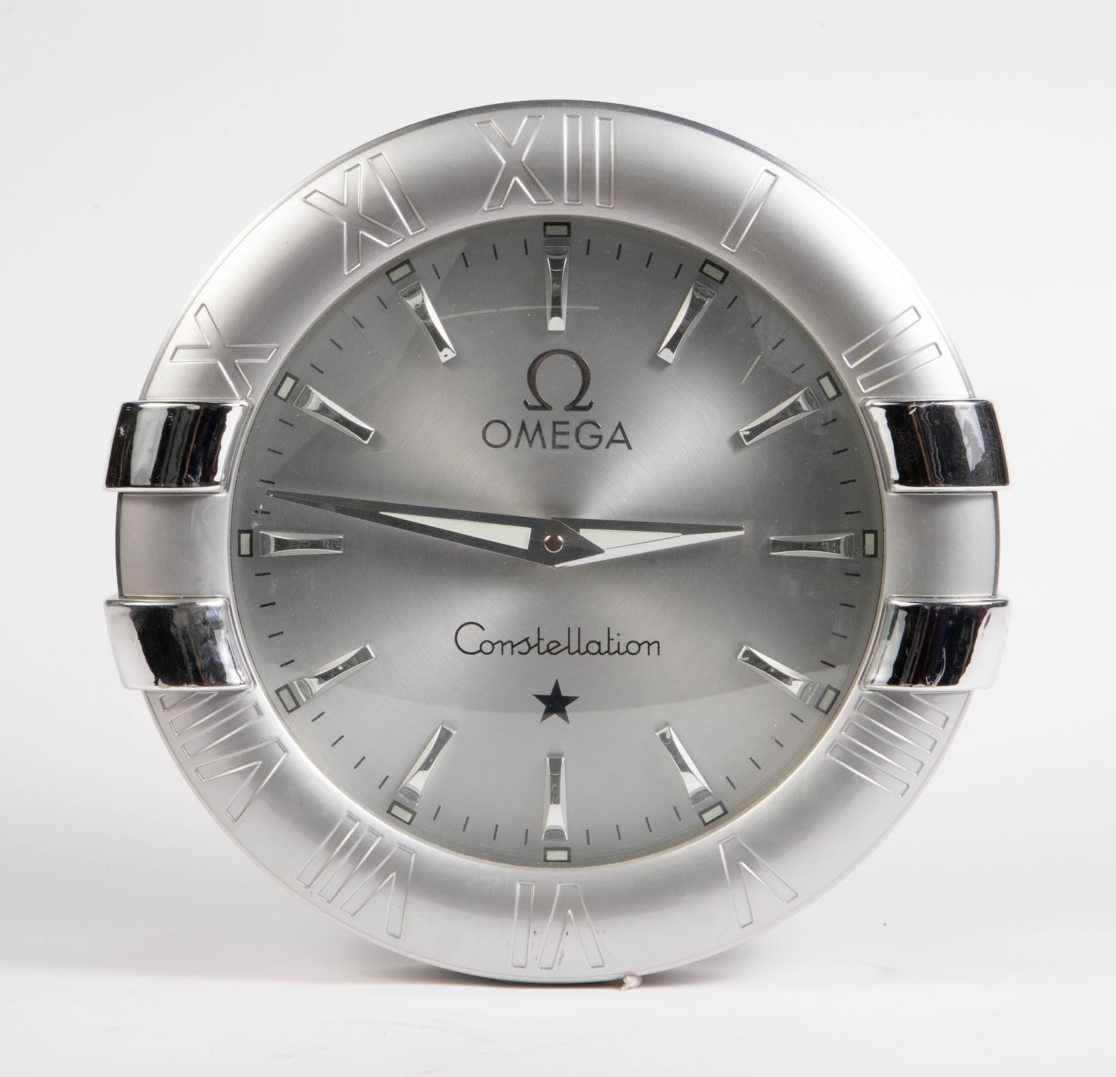 Omega Constellation Silver Tone Wall Clock.: This dealer display clock is possibly brushed aluminum. When tested, it appears to be in good working condition. It measures 13 3/4" x 13 1/2" x 2 1/4". It has some deep scratches on the frame, but ot