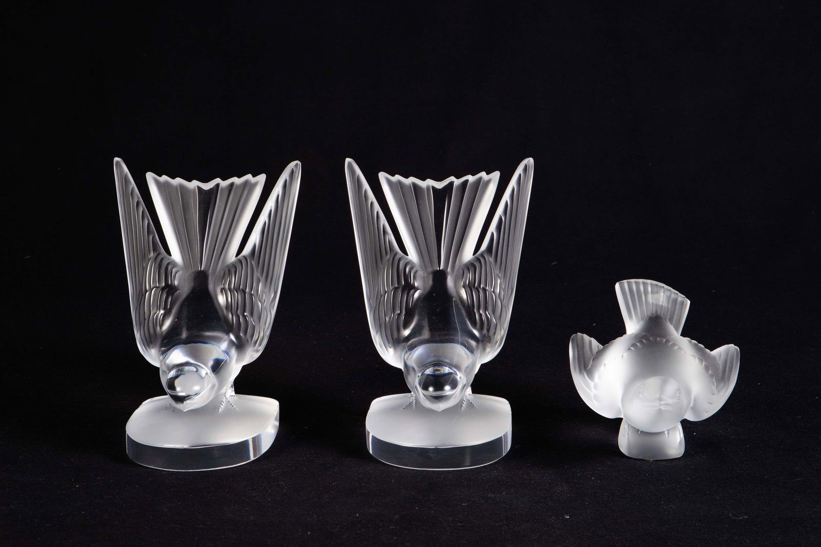 Lot: 3 Lalique Birds, inc. Hirondelles Bookends.: This lot includes a pair of Hirondelles bookends and a sparrow paperweight. The lot looks to be in very nice condition. Each bookend measures 4 1/4" x 3 3/8" x 6 1/4". The paperweight measures 5 3/8"