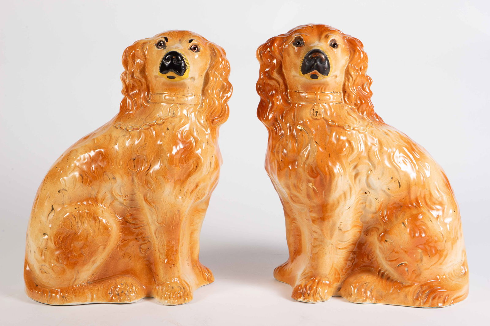 Pair of Painted Staffordshire Dogs w/ Glass Eyes.: They are tan and white, with black snouts. There is some crazing present, with a few faint cracks on the back, and one chip on the back. Each one measures approximately 9" x 5" x 13". In-house shippin