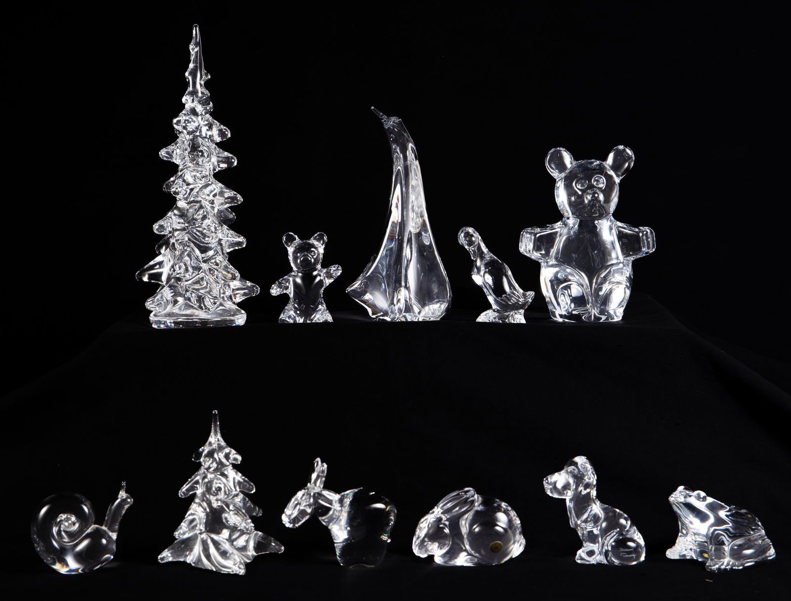 Lor of Crystal Figurines - Baccarat, Steuben, Daum: This lot includes evergreen trees, a sailboat, teddy bears, a dog, a rabbit, a snail, a duck, and a donkey. The brands include Daum France, Steuben, Val St. Lambert, Baccarat, Holmegaard, and more. Th