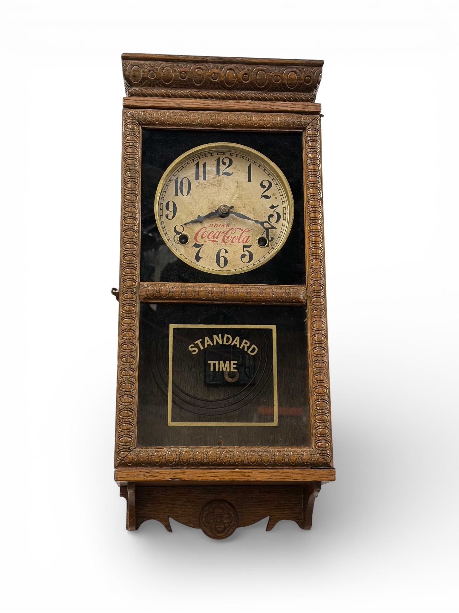 Coca-Cola Regulator Wall Clock.: The vintage wooden wall clock is marked Drink Coca-Cola / Reg. US. Pat. Off. on the face. The wooden case has carved decorative trim. It comes with the key and pendulum. It measures 6 1/2" x 8 1/8" x