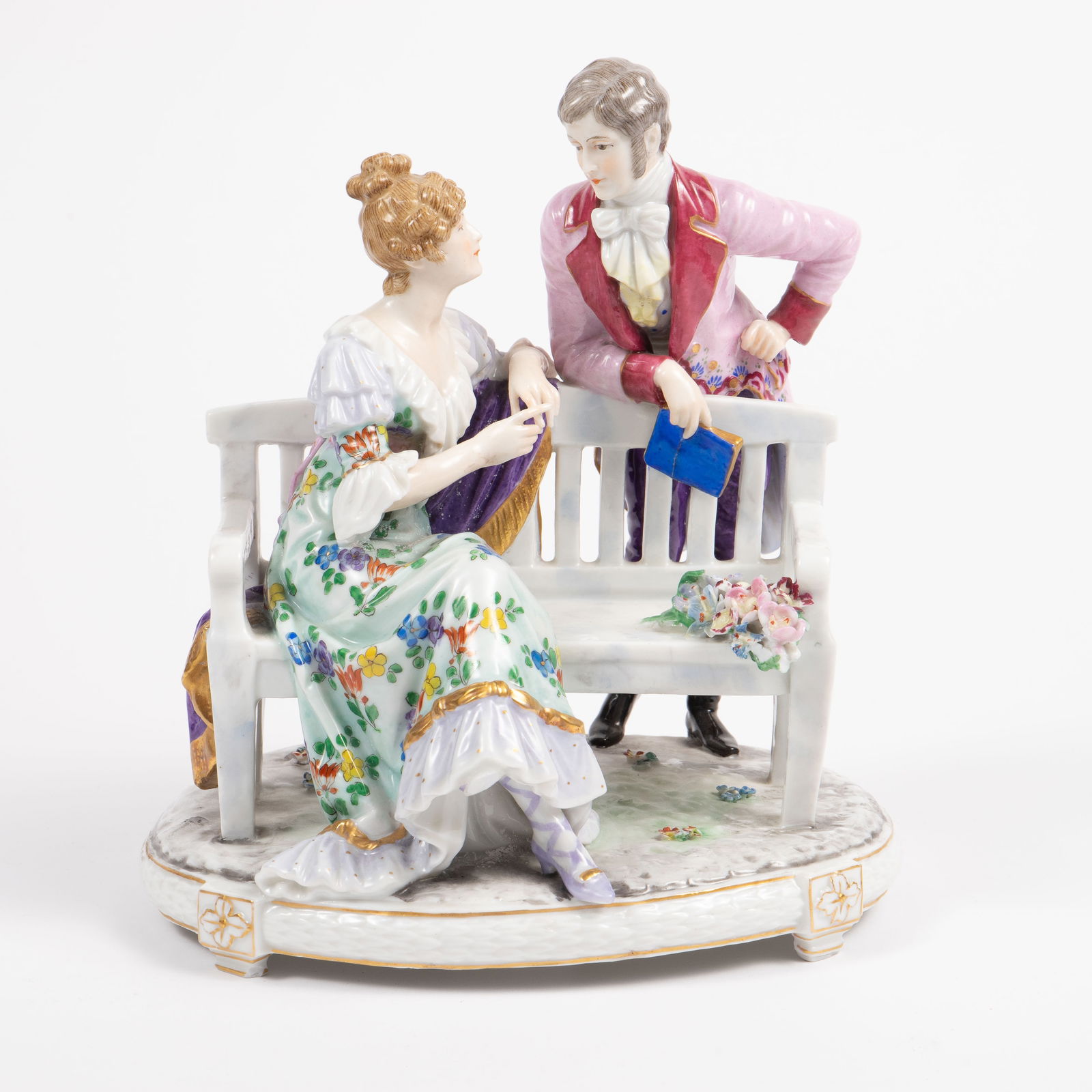 Possibly German Porceain Courting Figural Group.: The underside bears a Ludwigsburg or imitation Ludwigsburg mark. The small flowers have some chips, and the gentleman's book has a crack. The dimensions of the piece are 8 1/8" x 7 1/4" x 10". Third-p