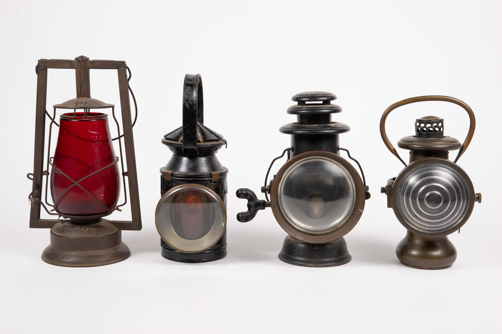 4 Mostly Railroad Lanterns Inc. Victor, Solar.: The lot contains 4 antique railroad lanterns. There is a Dietz Victor, BR SR 3077, Solar Pat. June 8, 1909, and Dietz Union Driving Lamp. The largest lamp measures 13 1/2" x 7 1/2" x 5 1/2". There are
