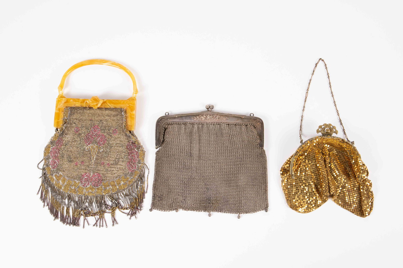 Lot of 3 Vintage Mesh Purses - Bakelite & More.: The lot contains 3 vintage handbags or purses. There is a silver toned piece with a silverplate frame, a gold tone piece with a dainty chain, and a beaded piece with fringe and a marbled yellow bakeli