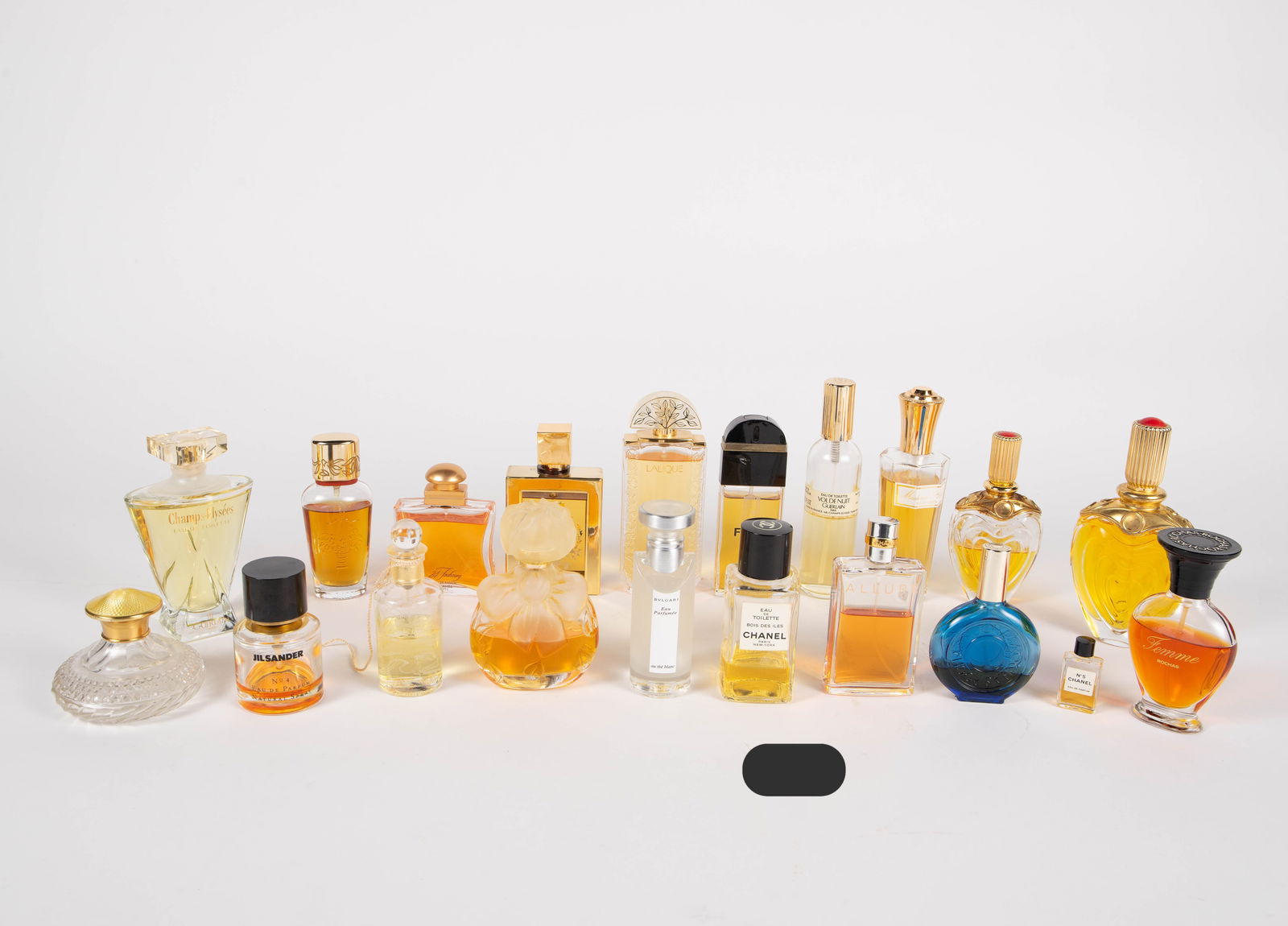 19 Vintage Perfumes Inc. Chanel, Hermes, Lalique.: The lot contains 18 mostly vintage perfumes with different fill levels. The lot also includes an empty crystal perfume container with a gold over sterling silver cap with a guilloche enamel top marked