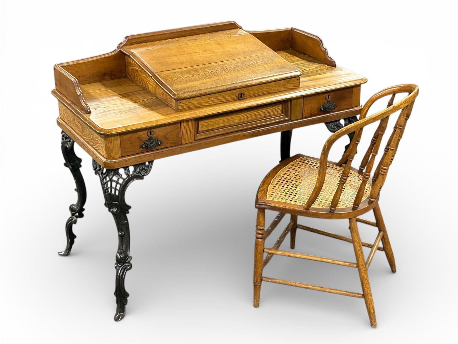 Victorian Oak Desk with Cast Iron Legs & Chair.: The antique oak desk has a gallery design with a hinged top. The top opens to an internal storage area which holds 2 antique ink containers. When the lift top opens, it has a mechanism that holds it o