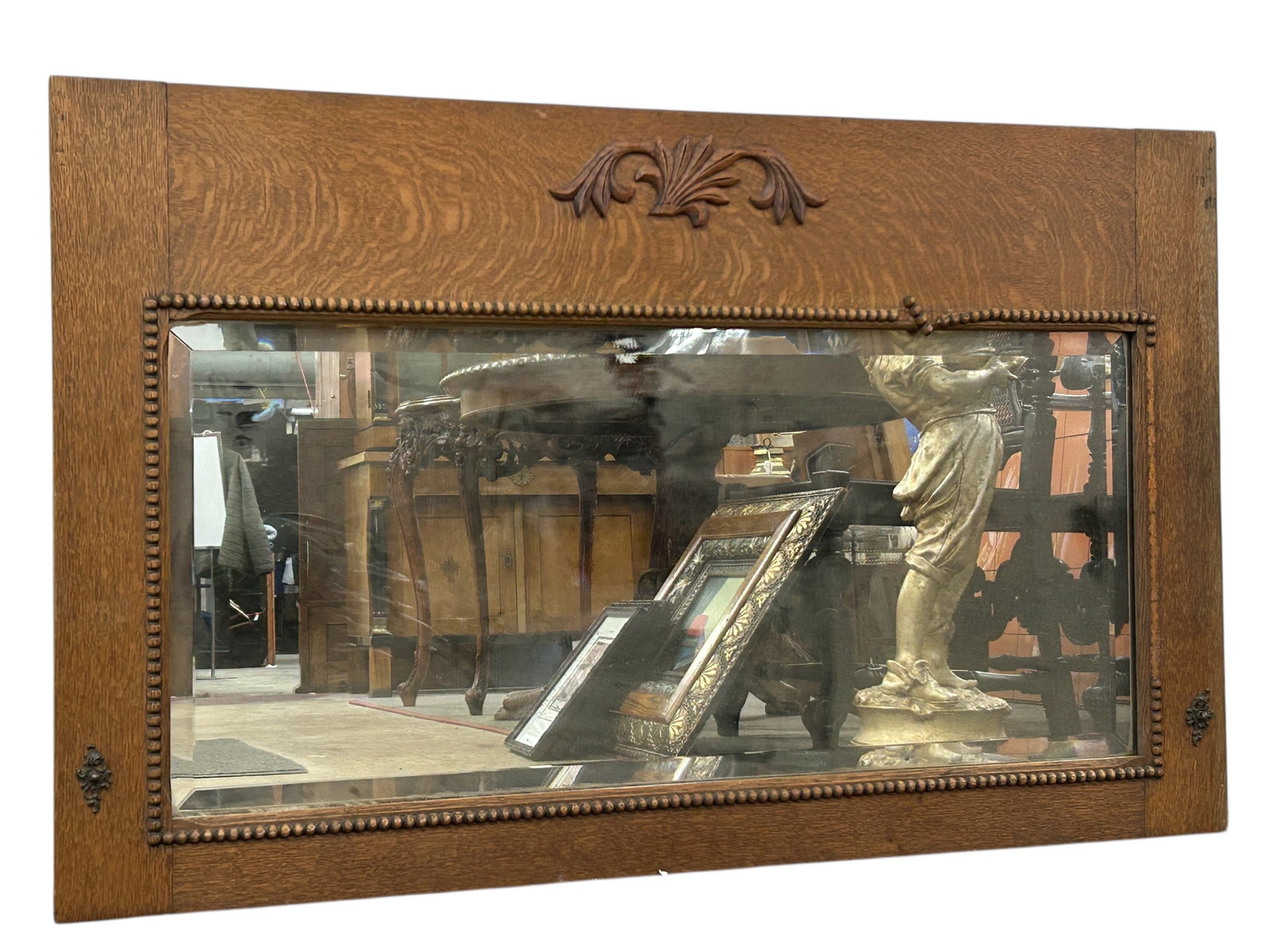 Bevelled Glass & Oak Wall Mirror.: The oak frame has floral carvings, beading, and brass decorations. The mirror glass is a little loose. There are scratches and indentations. Some of the beading is missing. It measures 29 1/2" tall an