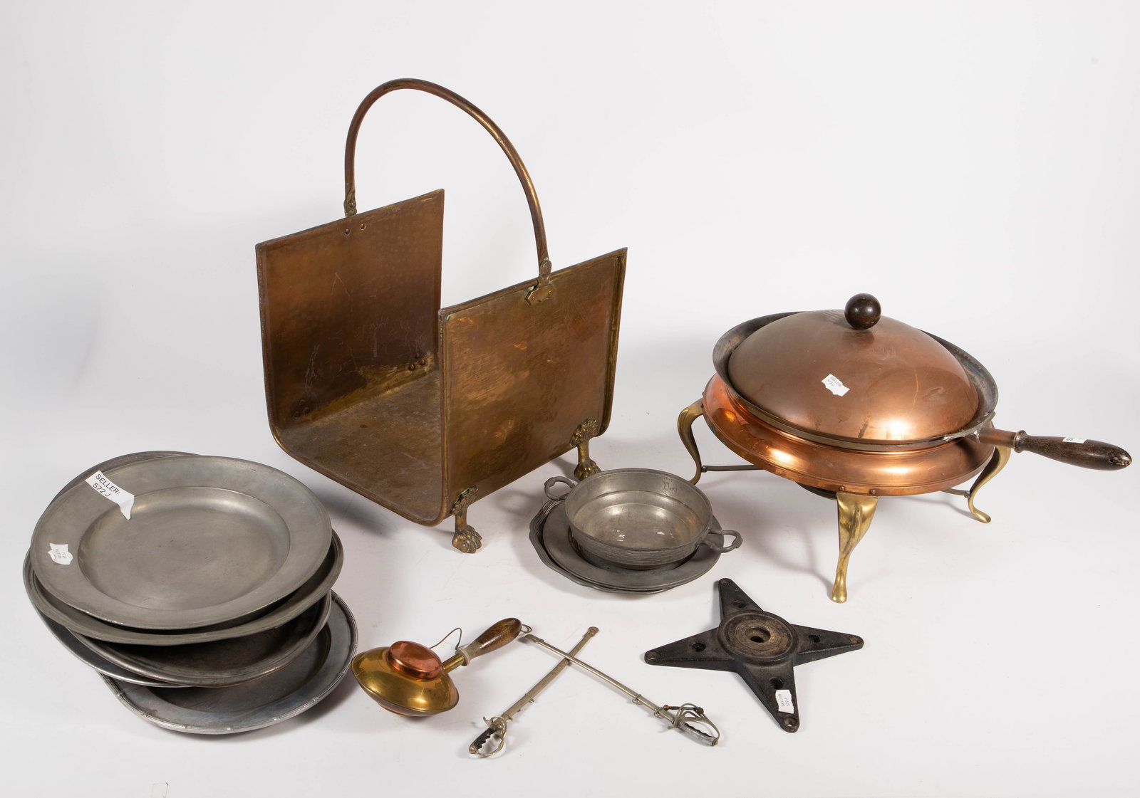 Lot of Old Kitchenware & Log Basket, inc. Brass.: The lot contains 16 items. There is a brass, copper, and metal lidded 12" pot with a warmer stand by Leumas, 3 etched metal plates marked London, some trays by Wilton Columbia U.S.A., a couple of mini