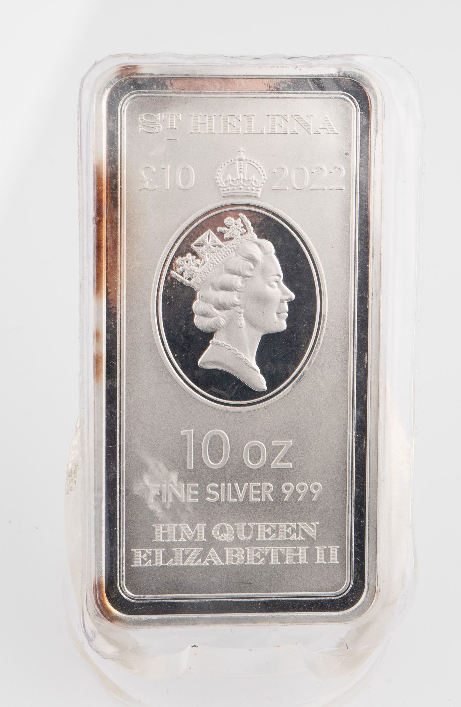 St. Helena 10 Ounce .999 Fine Silver Bar.: The 10 Ounce bar of .999 fine silver depicts Queen Elizabeth on one side and a sailboat on the other, along with The East India Company London branding. It measures roughly 3 1/2" x 1 3/4". There is s