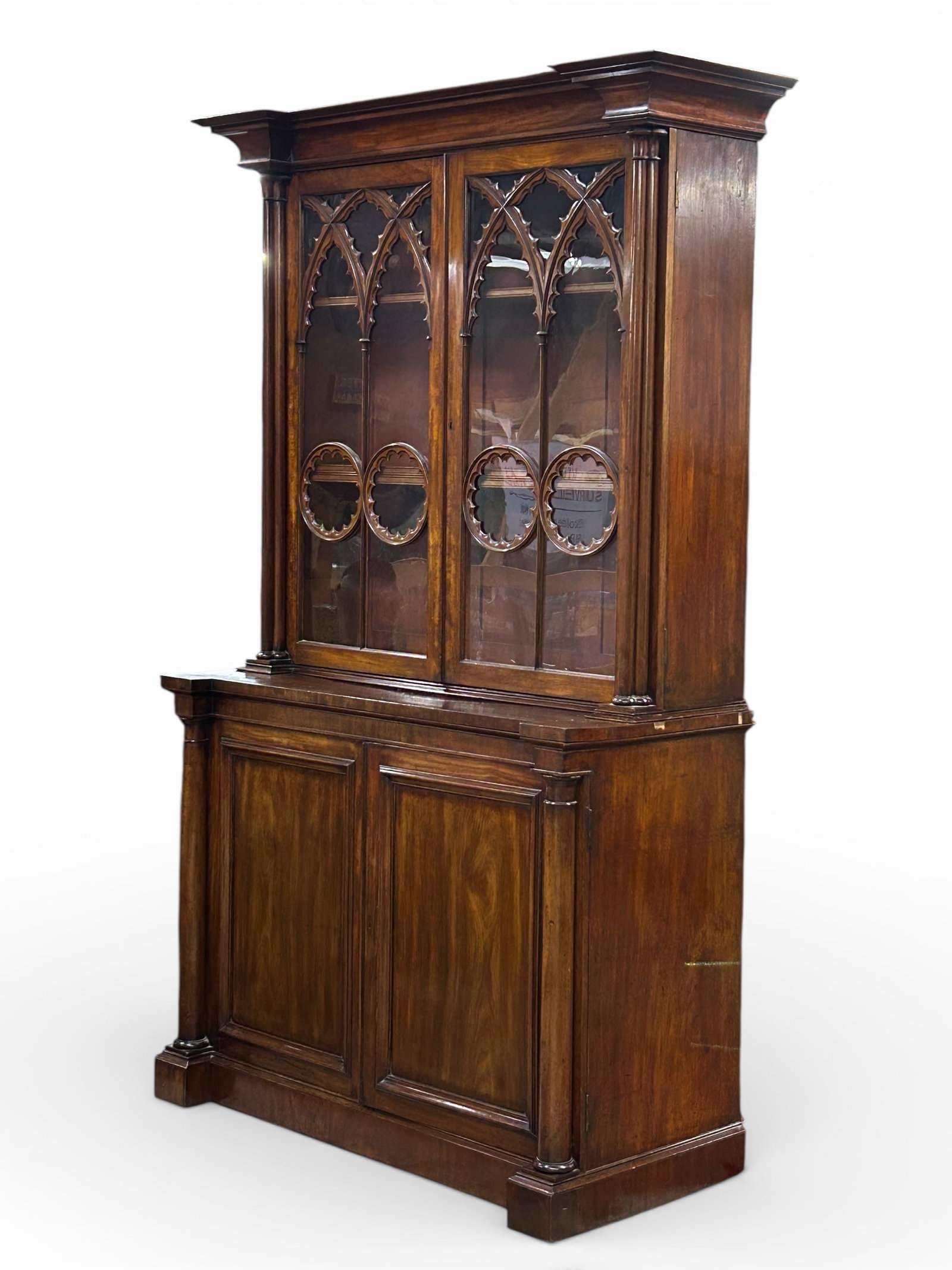 Antique Gothic Revival Bookcase.: This fine bookcase or display cabinet has two tall doors with carved fretwork, three interior adjustable shelves, a carved crown, and columns. The lower section has two panel-front doors with two inte