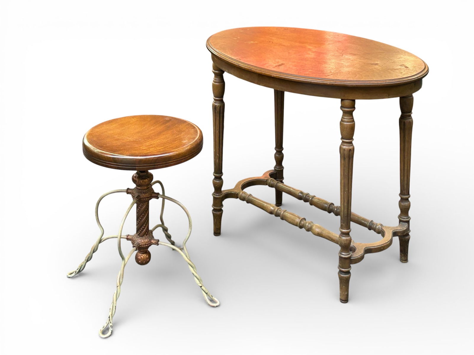 Wrought Iron Piano Stool & Walnut Side Table.: The stool is adjustable, and has a round walnut seat, a brass decorated base, and wrought iron legs. It is manufactured by Tonk of Chicago & New York. The walnut side table has carved legs with a stre