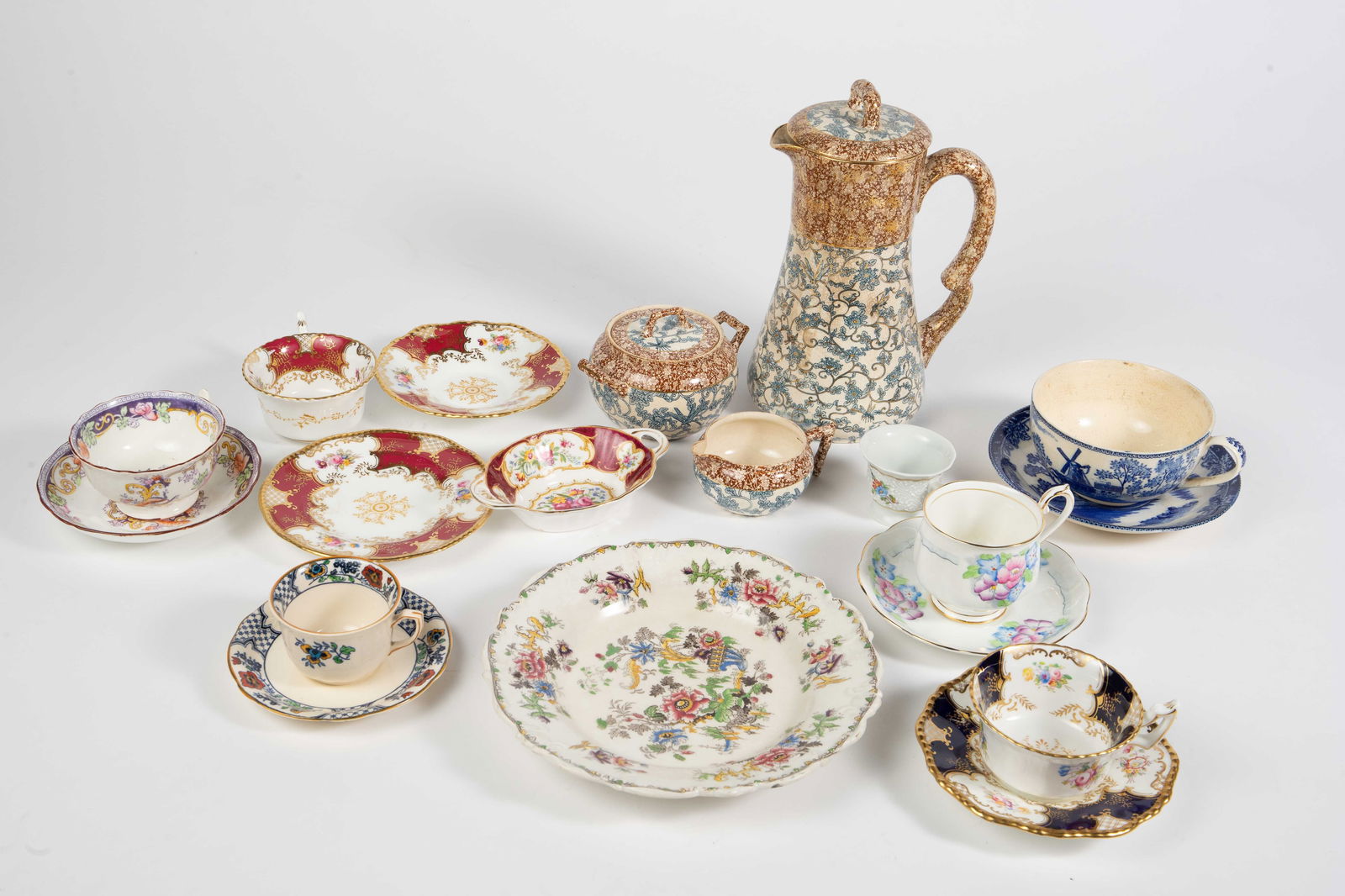 Lot Mostly English Ceramics - Doulton Burslem, Etc: The lot contains 19 pieces of vintage / antique porcelain. The lot contains a variety of cups, saucers, and plates, and a 3 piece set, which includes a lidded pitcher or pot, a sugar bowl and a creame
