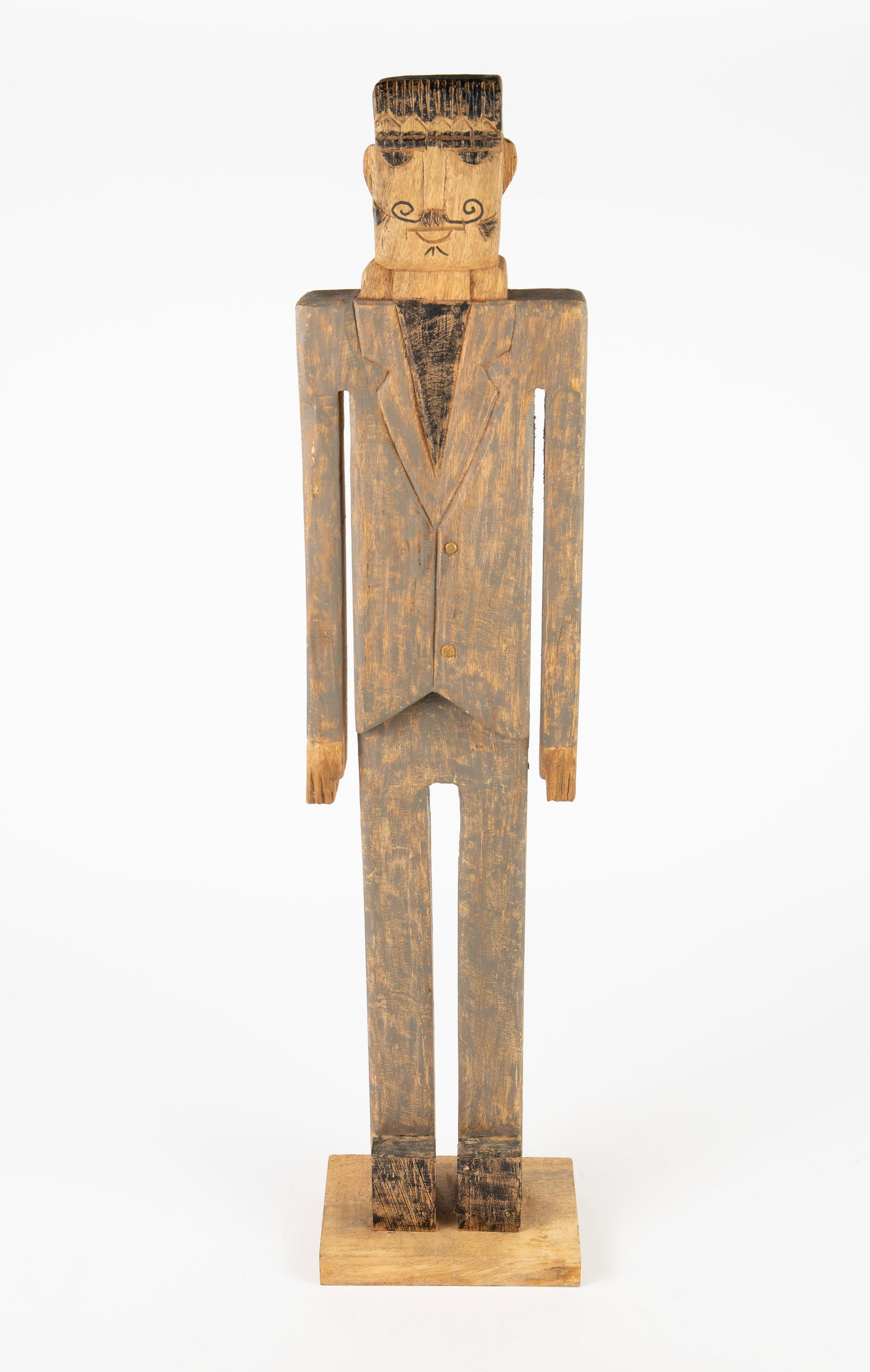 Carved Folk Art Wood Sculpture of Man w/ Moustache: The artist is unknown. It is a primitive style rustic sculpture of a dark haired man in a suit, with a curling moustache. The right arm has a crack; overall, the piece looks to be in good condition.