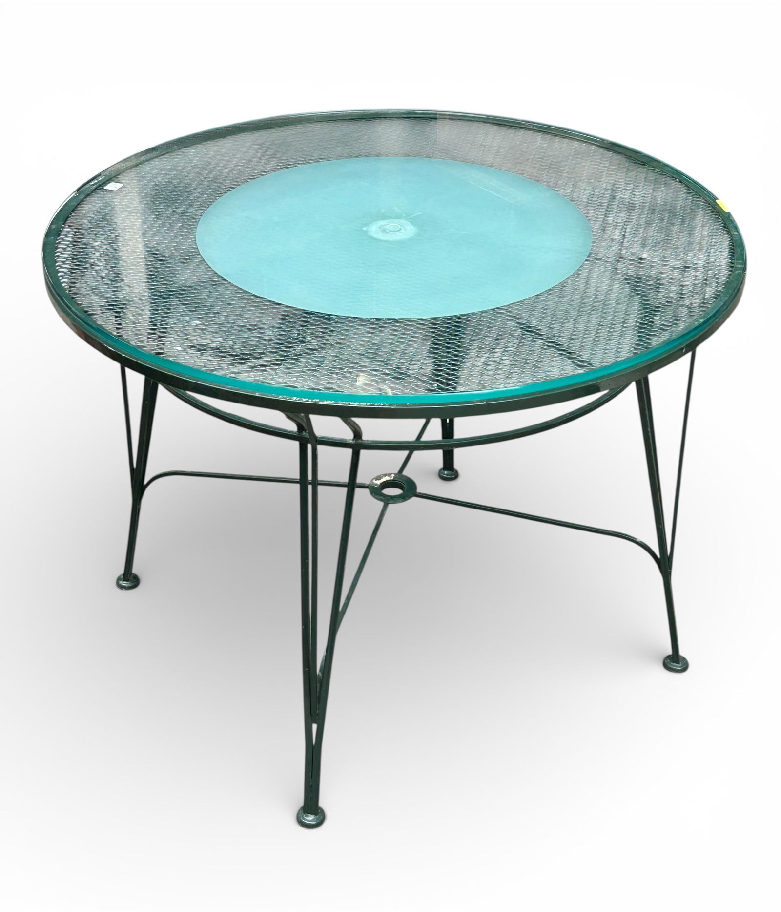 Round Iron Patio Table with Glass Top.: The circular patio table is painted dark green, and has a glass top that is partially frosted. It is in nice condition, with only very minor wear. There is a hole bored into the top of the glass to